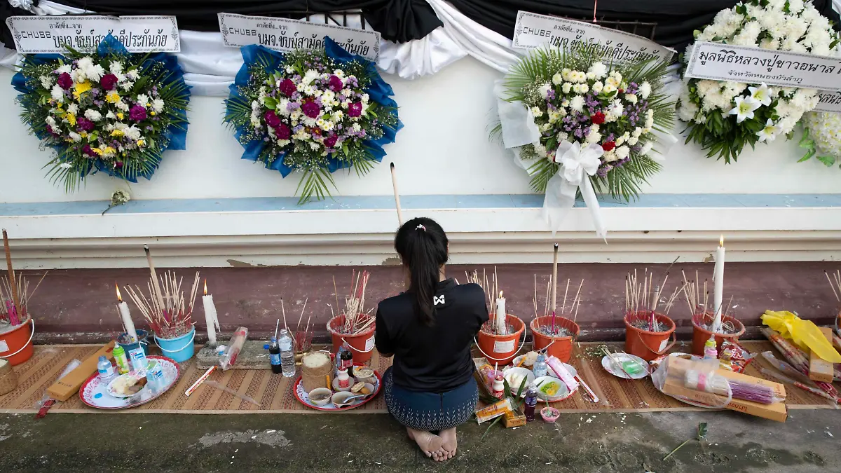  October 8, 2022, Uthai Sawan, Nong Bua Lamphu, Thailand: Ms. Panadda, 27 years old, lights incense and prays outside of Wat Rat Samakee temple in Nong Bua Lamphu province, Thailand while funeral rites for 6 of her family members take place inside, killed during the Uthai Sawan day care center massacre. An assailant used a combination of guns and knives to kill at least 35 people at the day care center, most of the victims being young children. Uthai Sawan Thailand - ZUMAt128 20221008_zap_t128_025 Copyright: xAdryelxTalamantesx