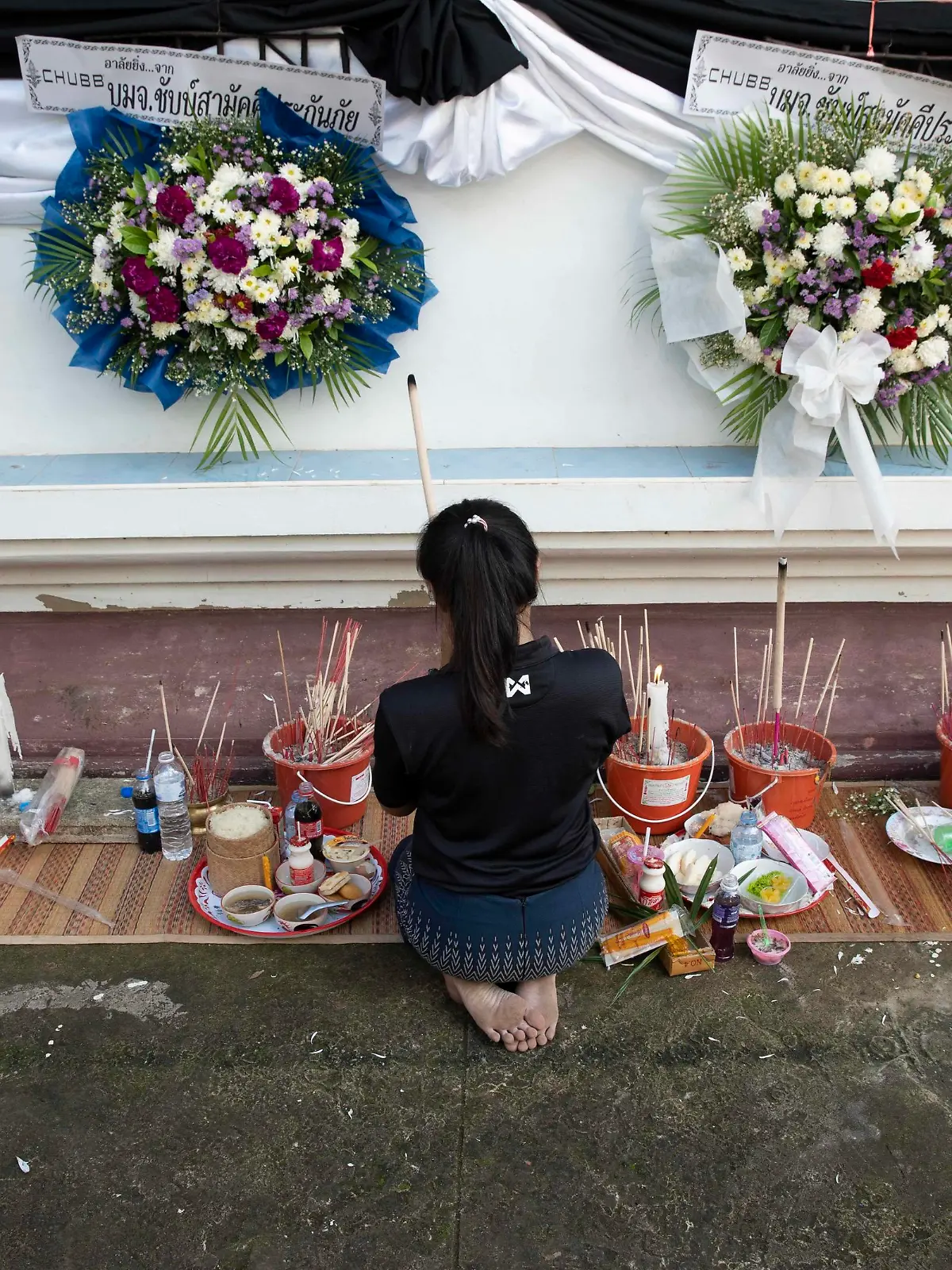  October 8, 2022, Uthai Sawan, Nong Bua Lamphu, Thailand: Ms. Panadda, 27 years old, lights incense and prays outside of Wat Rat Samakee temple in Nong Bua Lamphu province, Thailand while funeral rites for 6 of her family members take place inside, killed during the Uthai Sawan day care center massacre. An assailant used a combination of guns and knives to kill at least 35 people at the day care center, most of the victims being young children. Uthai Sawan Thailand - ZUMAt128 20221008_zap_t128_025 Copyright: xAdryelxTalamantesx
