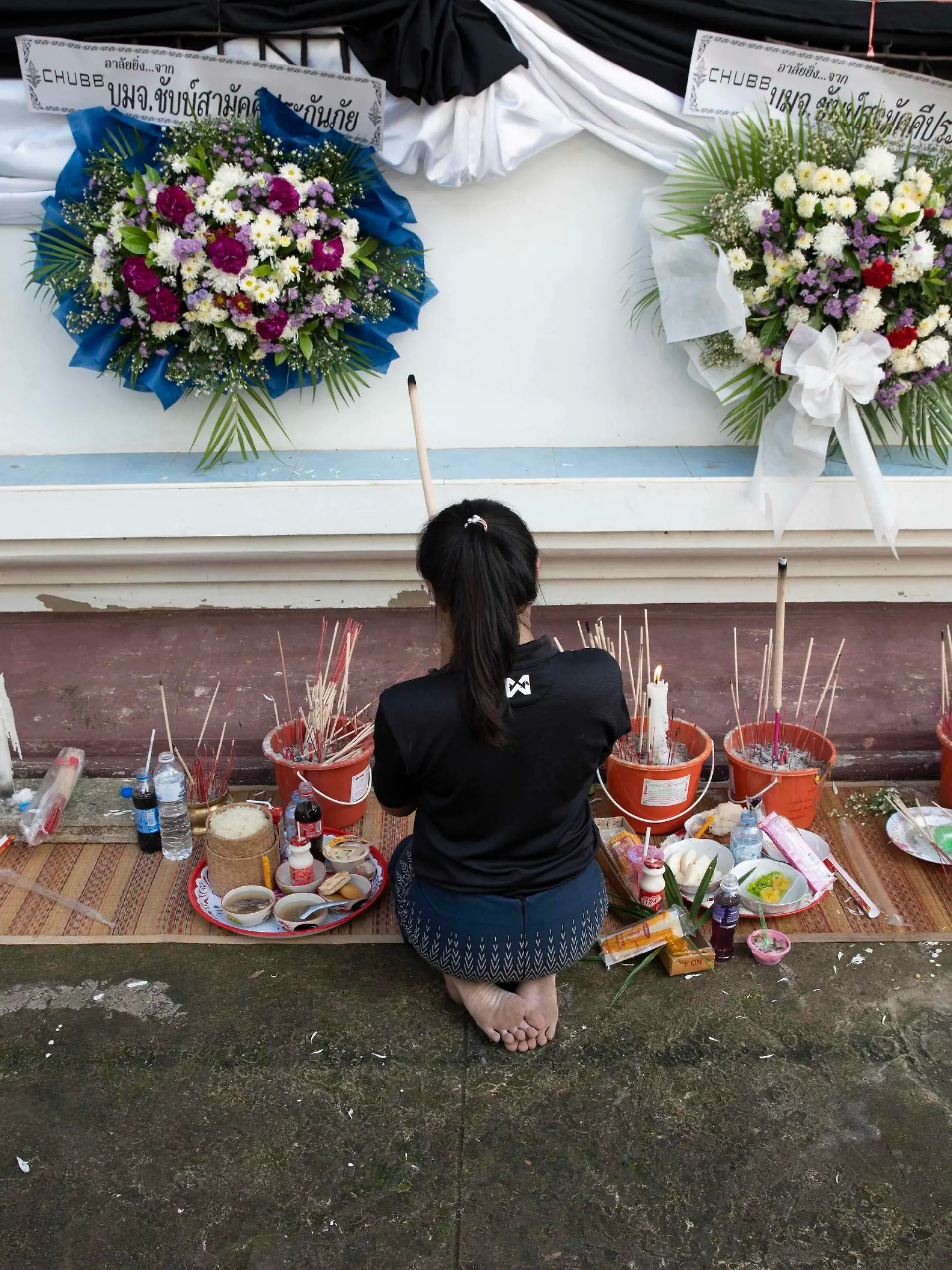  October 8, 2022, Uthai Sawan, Nong Bua Lamphu, Thailand: Ms. Panadda, 27 years old, lights incense and prays outside of Wat Rat Samakee temple in Nong Bua Lamphu province, Thailand while funeral rites for 6 of her family members take place inside, killed during the Uthai Sawan day care center massacre. An assailant used a combination of guns and knives to kill at least 35 people at the day care center, most of the victims being young children. Uthai Sawan Thailand - ZUMAt128 20221008_zap_t128_025 Copyright: xAdryelxTalamantesx
