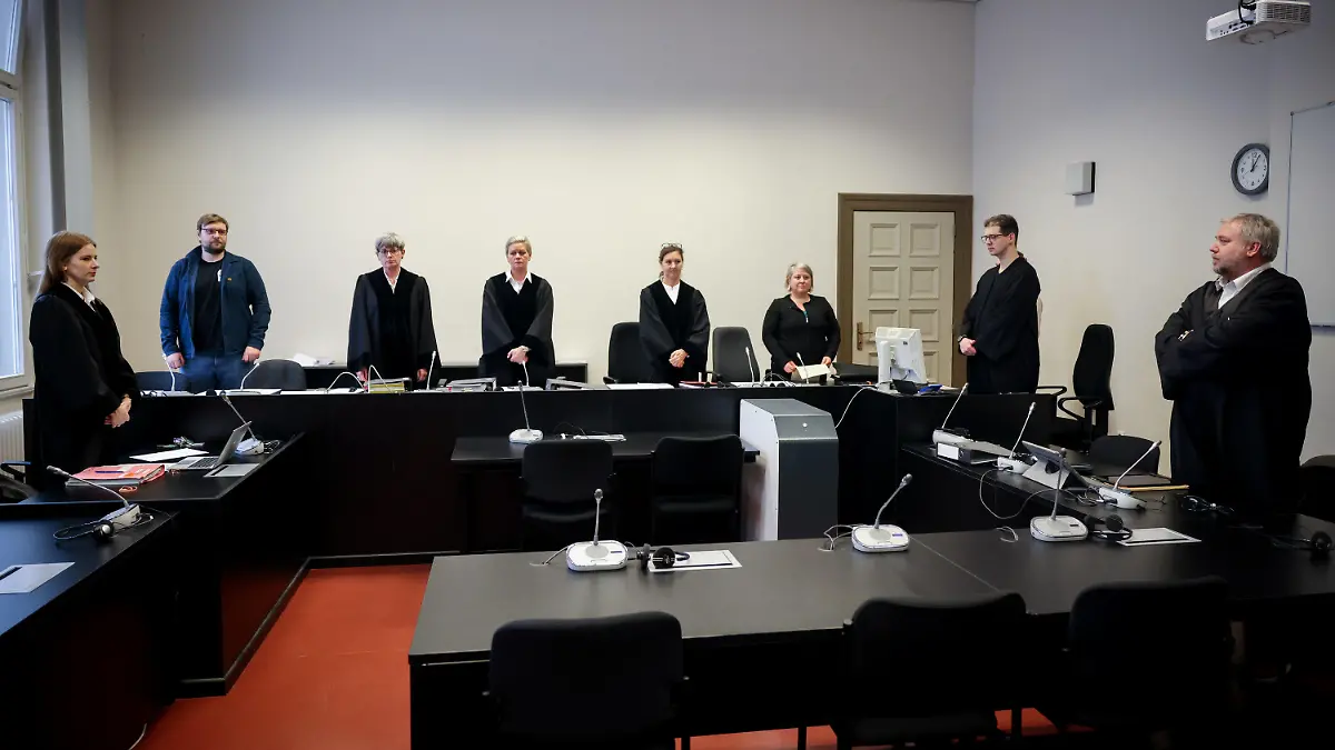 13.02.2024, Hamburg: Jessica Koerner (4.v.l), Vorsitzende Richterin am Landgericht, Anwalt Christian Lange (r) neben dem noch leeren Platz seiner Mandantin sowie weitere Prozessbeteiligte stehen zu Beginn eines Prozesses im Gerichtssaal im Strafjustizgebäude. Eine 33-Jährige muss sich von Dienstag an wegen Totschlags, versuchten Mordes und gefährlicher Körperverletzung vor dem Landgericht Hamburg verantworten. Foto: Christian Charisius/dpa +++ dpa-Bildfunk +++
