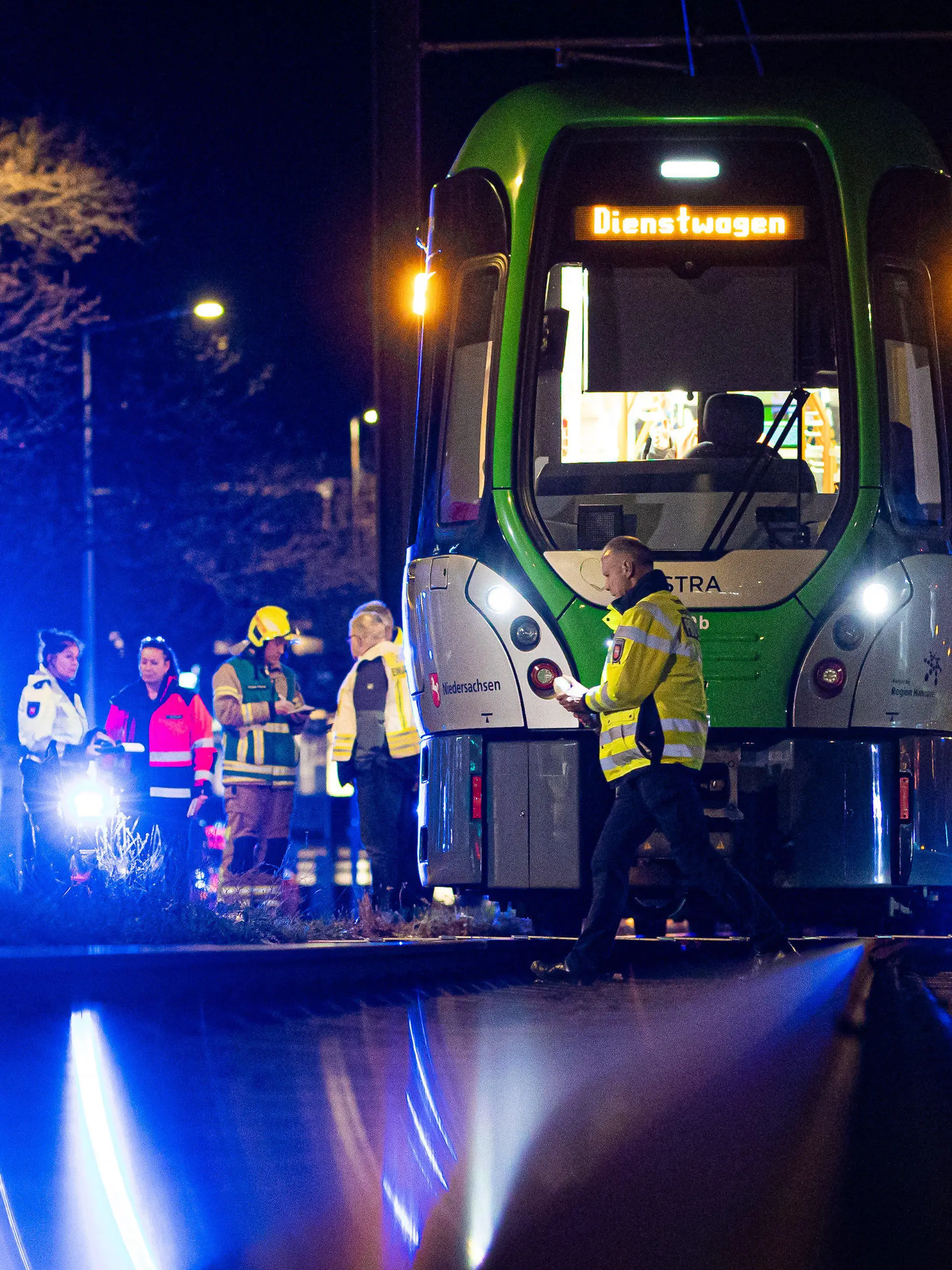 13.02.2024, Niedersachsen, Hannover: Einsatzkräfte stehen am Abend nach einem Unfall neben einer Stadtbahn. Eine Frau ist von der Stadtbahn erfasst und lebensgefährlich verletzt worden. Foto: Moritz Frankenberg/dpa +++ dpa-Bildfunk +++