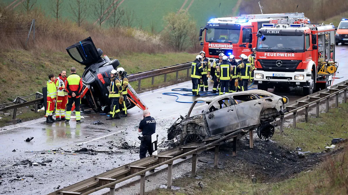 ARCHIV - 01.04.2023, Thüringen, Bad Langensalza: Ein ausgebrannter Pkw und ein weiteres verunfalltes Fahrzeug stehen an der Unfallstelle auf der B247. (zu dpa: «Angeklagter räumt Vorwürfe nach Unfall mit sieben Toten ein») Foto: Silvio Dietzel/dpa +++ dpa-Bildfunk +++