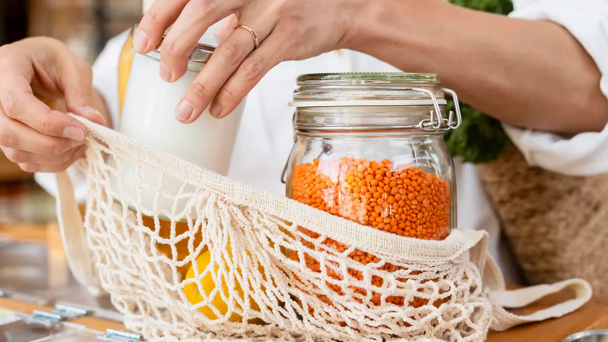 Woman putting jars in mesh bag at table model released, Symbolfoto property released, NDEF01103
