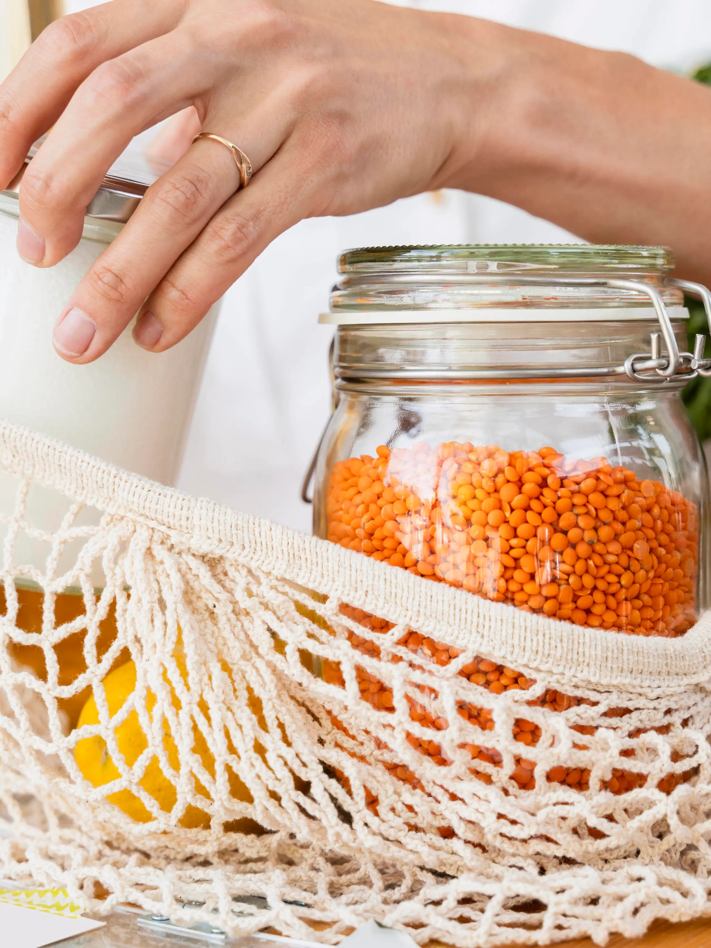 Woman putting jars in mesh bag at table model released, Symbolfoto property released, NDEF01103