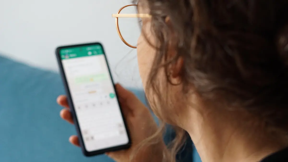 PRODUKTION - 29.09.2023, Berlin: Eine junge Frau hält ihr Smartphone in der Hand und liest eine Whatsapp-Nachricht. (zu dpa: «WhatsApp vermehrt von Unternehmen für Bewerbungen genutzt») Foto: Weronika Peneshko/dpa +++ dpa-Bildfunk +++