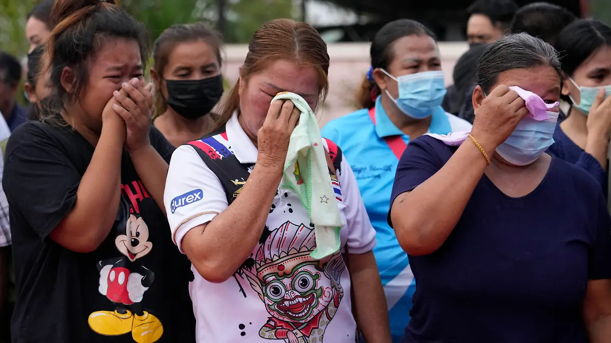 Relatives and friends mourn during a ceremony for those killed in the attack on the Young Children's Development Center in the rural town of Uthai Sawan, north eastern Thailand, Friday, Oct. 7, 2022. A former policeman facing a drug charge burst into a day care center in northeastern Thailand on Thursday, killing dozens of preschoolers and teachers before shooting more people as he fled in the deadliest rampage in the nation's history. (AP Photo/Sakchai Lalit)