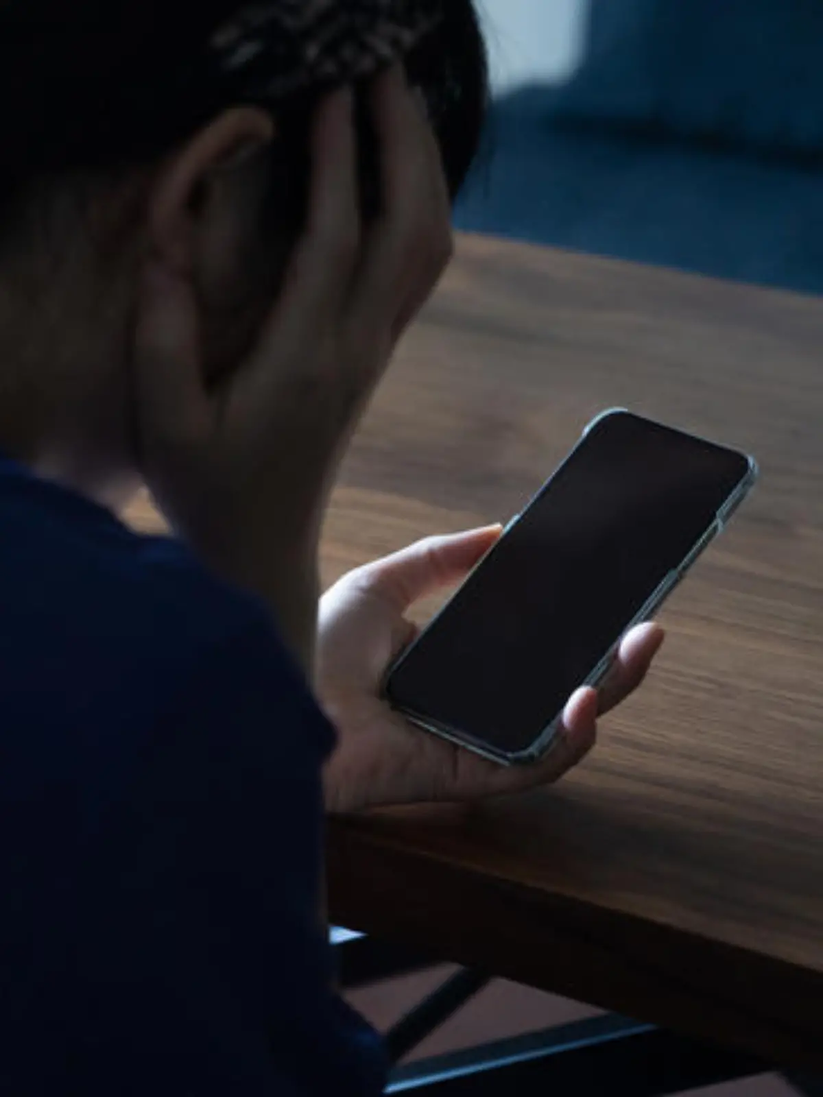 A woman who is frightened by a call coming from her phone.
She is holding her phone in a dark room.
A stalker on a social networking site.
Japanese female model.