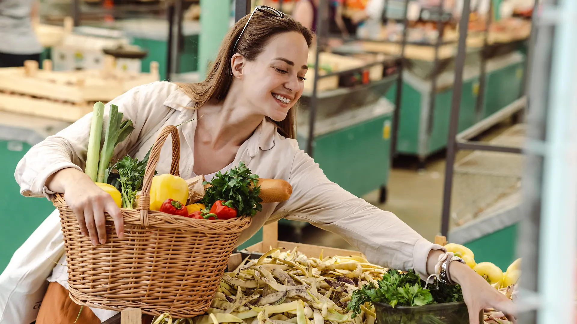 Smiling young woman looking for fresh vegetables on the farmers market