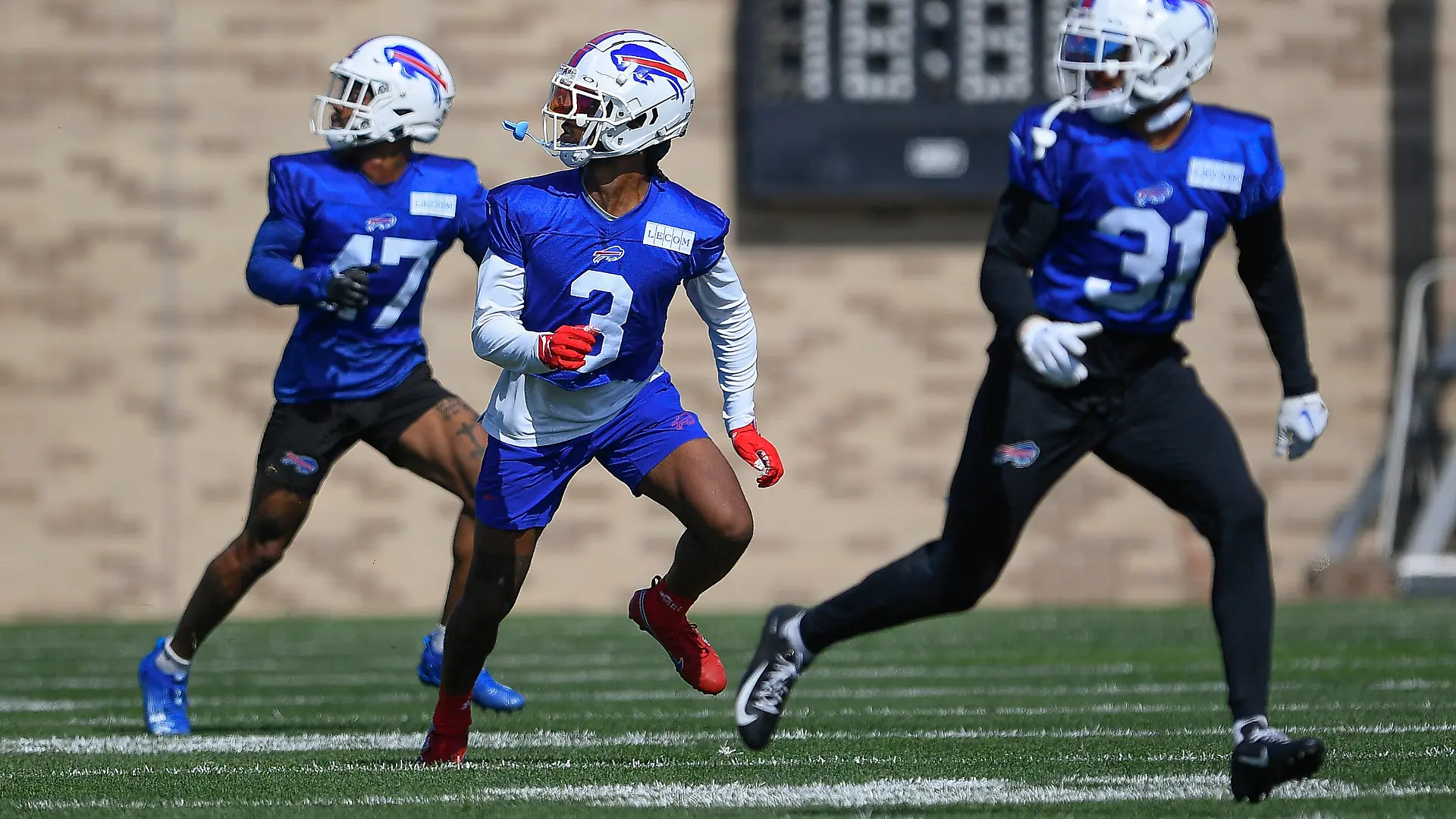Buffalo Bills safety Damar Hamlin, center, runs a drill with cornerback Christian Benford, left, and safety Dean Marlowe during practice at the NFL football team's training camp in Pittsford, N.Y., Sunday, July 30, 2023. (AP Photo/Adrian Kraus)