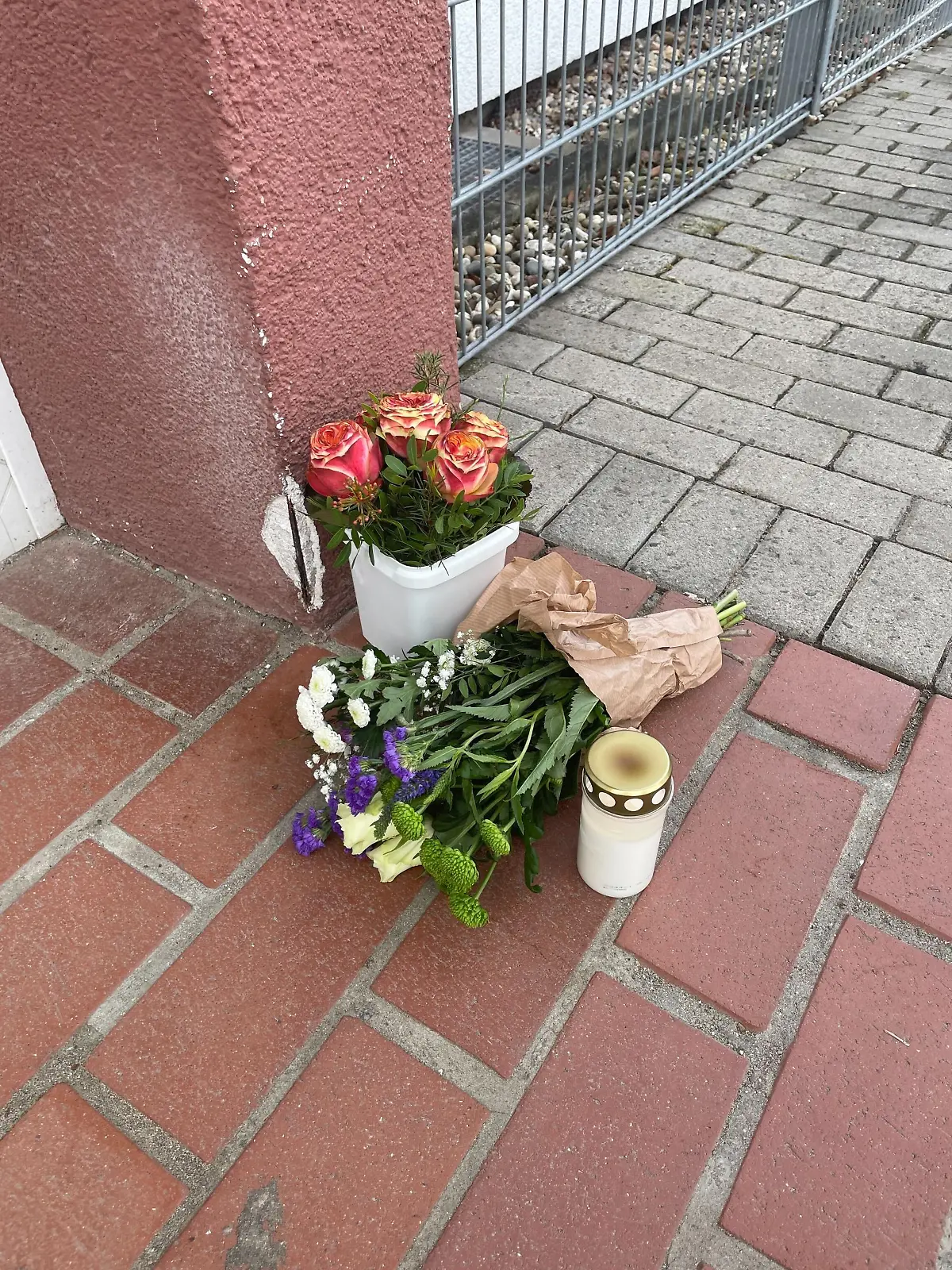 Vor dem Kindergarten drücken Menschen durch Blumen ihre Anteilnahme aus