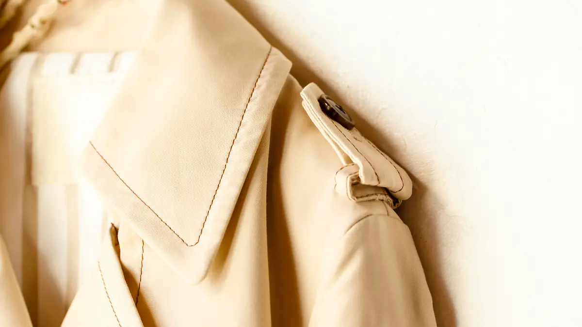 A beige elegant trench coat isolated over white. Close up