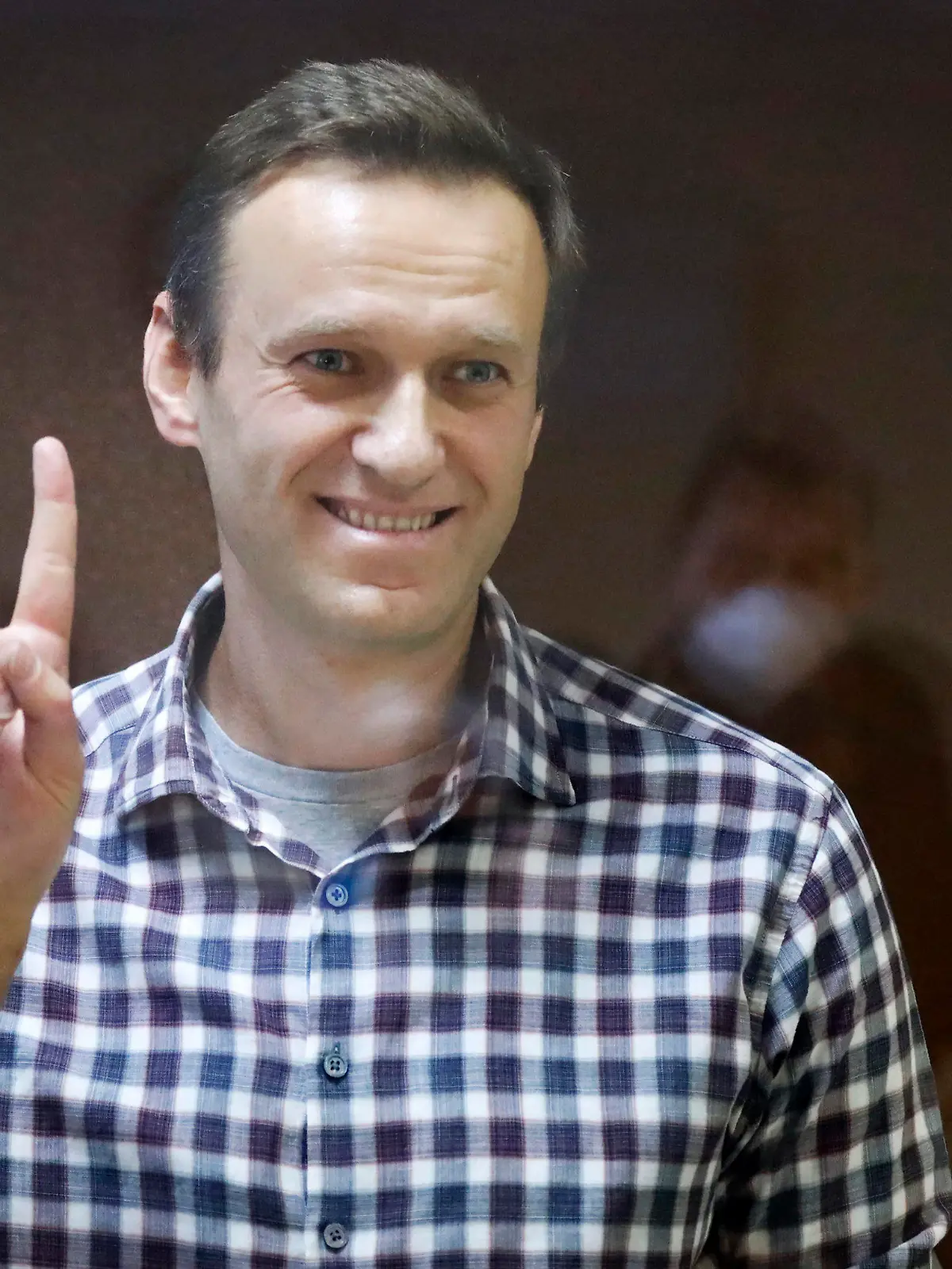 ARCHIV - 20.02.2021, Russland, Moskau: Alexej Nawalny, russischer Oppositionsführer, zeigt das Sieges-Zeichen, während er in einem Käfig im Bezirksgericht Babuschkinski steht. Der russische Oppositionspolitiker Alexej Nawalny ist nach Angaben der Justiz in Haft gestorben. Das teilte die Gefängnisverwaltung des nordrussischen Gebietes Jamal nach Angaben der Agentur Tass mit. (zu dpa: «Russische Justiz: Kremlgegner Nawalny in Haft gestorben») Foto: Alexander Zemlianichenko/AP/dpa +++ dpa-Bildfunk +++