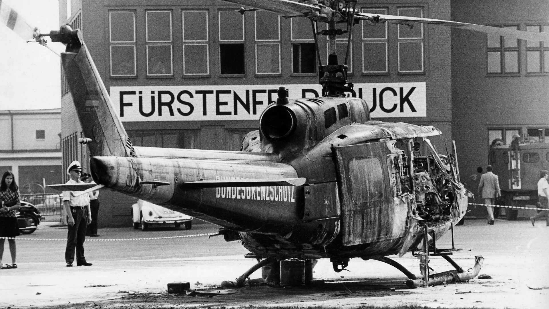 Auf dem Militärflughafen Fürstenfeldbruck steht am 06.09.1972 das Wrack eines Hubschraubers vom Bundesgrenzschutz. In ihm kommen in der Nacht zum 06.09.1972 neun Mitglieder der an den Olympischen Sommerspielen von München teilnehmenden israelischen Mannschaft ums Leben. Sie waren von arabischen Terroristen der Gruppe "Schwarzer September" am 05.09.1972 bei einem Überfall auf ihr Quartier im Olympischen Dorf als Geiseln genommen worden. Der tragisch endenden Befreiungsaktion auf dem Flugplatz von Fürstenfeldbruck ging die Ermordung zweier israelischer Sportler im Olympischen Dorf voraus. Bei der Befreiungsaktion kommen auch ein Münchner Polizist und fünf Terroristen ums Leben.