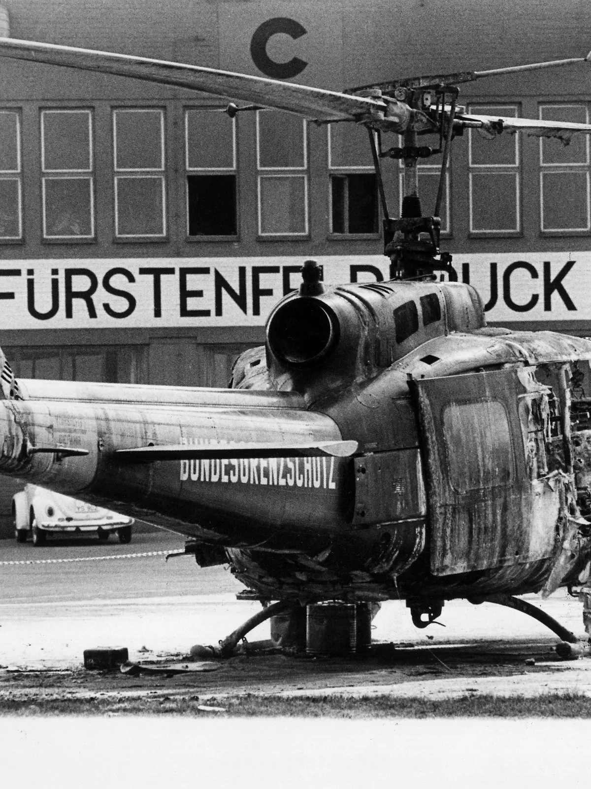 Auf dem Militärflughafen Fürstenfeldbruck steht am 06.09.1972 das Wrack eines Hubschraubers vom Bundesgrenzschutz. In ihm kommen in der Nacht zum 06.09.1972 neun Mitglieder der an den Olympischen Sommerspielen von München teilnehmenden israelischen Mannschaft ums Leben. Sie waren von arabischen Terroristen der Gruppe "Schwarzer September" am 05.09.1972 bei einem Überfall auf ihr Quartier im Olympischen Dorf als Geiseln genommen worden. Der tragisch endenden Befreiungsaktion auf dem Flugplatz von Fürstenfeldbruck ging die Ermordung zweier israelischer Sportler im Olympischen Dorf voraus. Bei der Befreiungsaktion kommen auch ein Münchner Polizist und fünf Terroristen ums Leben.