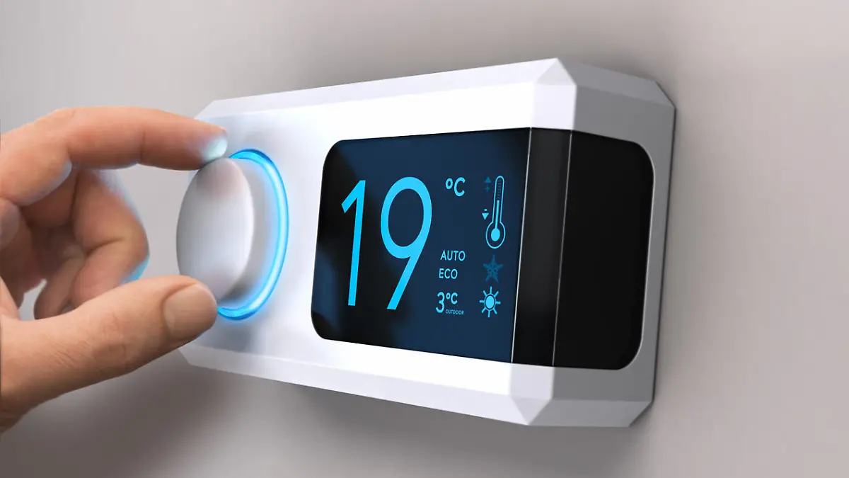 Hand turning a home thermostat knob to set temperature on energy saving mode. celcius units. Composite image between a photography and a 3D background.