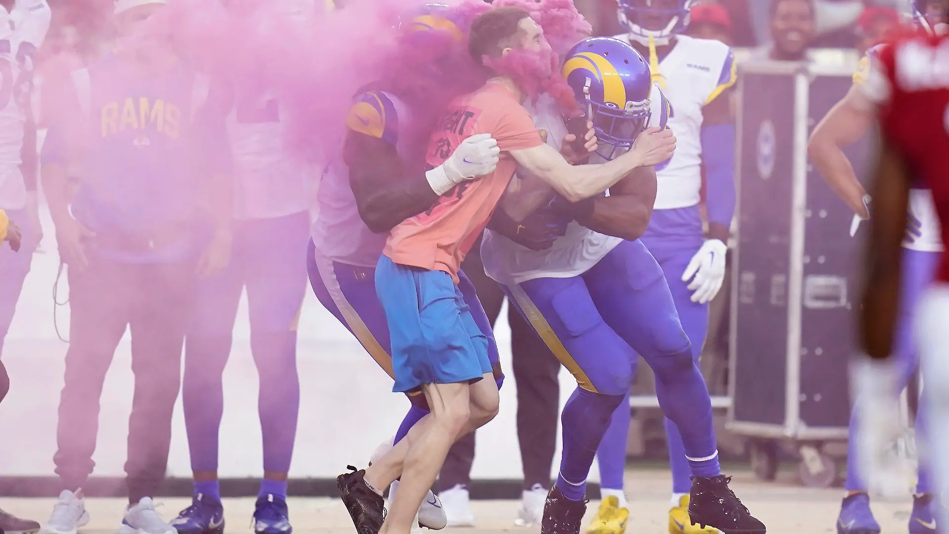 A protester is hit by Los Angeles Rams defensive end Takkarist McKinley, middle left, and linebacker Bobby Wagner during the first half of an NFL football game between the San Francisco 49ers and the Rams in Santa Clara, Calif., Monday, Oct. 3, 2022. (AP Photo/Godofredo A. Vásquez)