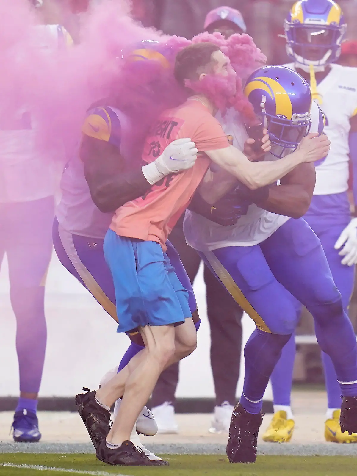 A protester is hit by Los Angeles Rams defensive end Takkarist McKinley, middle left, and linebacker Bobby Wagner during the first half of an NFL football game between the San Francisco 49ers and the Rams in Santa Clara, Calif., Monday, Oct. 3, 2022. (AP Photo/Godofredo A. Vásquez)
