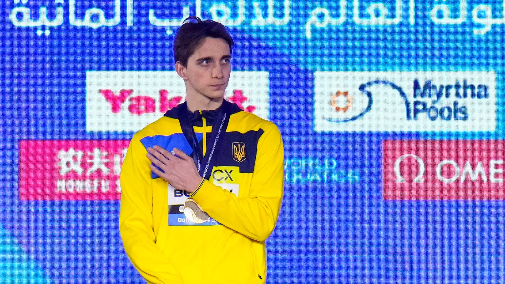 17.02.2024, Katar, Doha: Schwimmen: Weltmeisterschaft, 50 m Freistil, Männer, Finale: Wladyslaw Buchow aus der Ukraine steht nach seinem Sieg im 50-Meter-Freistil-Finale der Männer auf dem Podium. Foto: Hassan Ammar/AP +++ dpa-Bildfunk +++