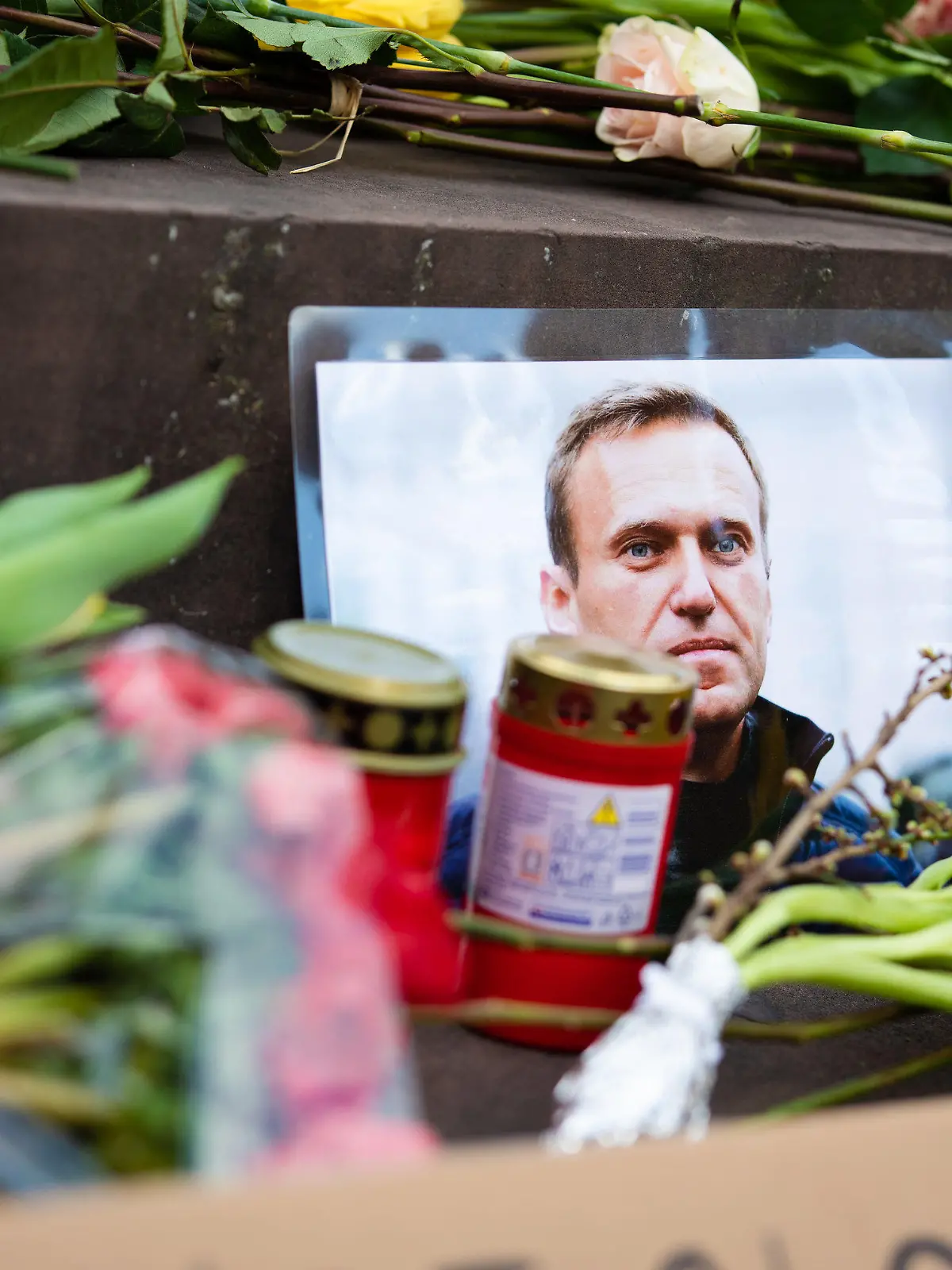 17.02.2024, Baden-Württemberg, Stuttgart: Nach dem Tod von Alexej Nawalny liegen bei einer Andacht Blumen, Kerzen und Schriftzüge am Stuttgarter Schillerplatz. Nawalny starb am 16.02.2024 im Alter von 47 Jahren nach Angaben der Justiz in einem sibirischen Straflager. Foto: Christoph Schmidt/dpa +++ dpa-Bildfunk +++