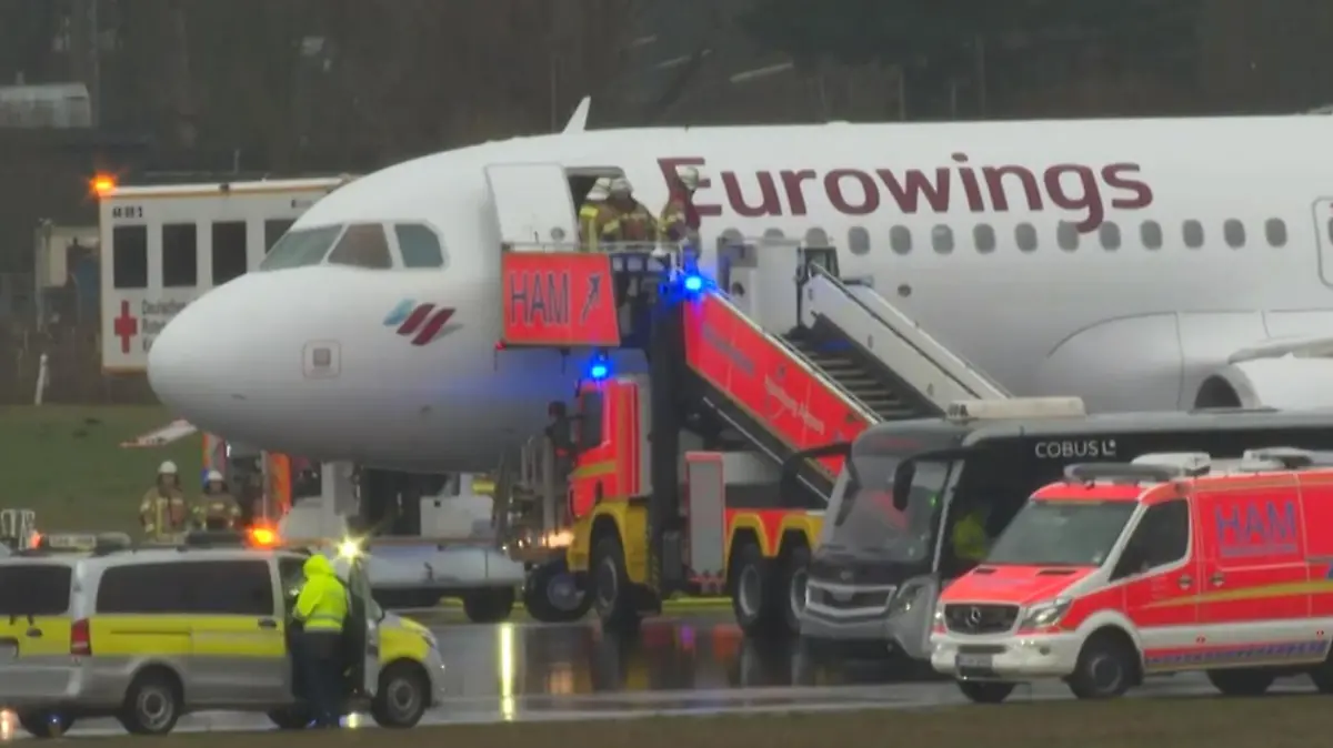 Ein Flugzeug mit Feuerwehrfahrzeugen davor.
