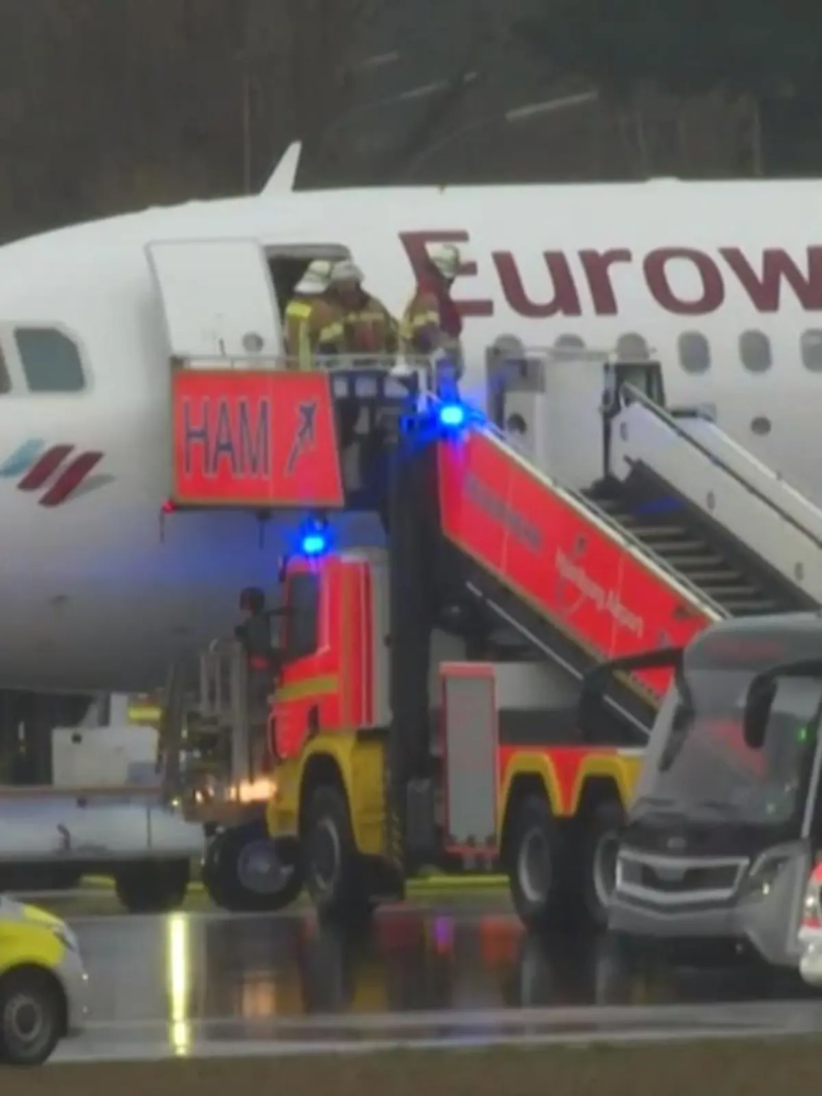 Ein Flugzeug mit Feuerwehrfahrzeugen davor.