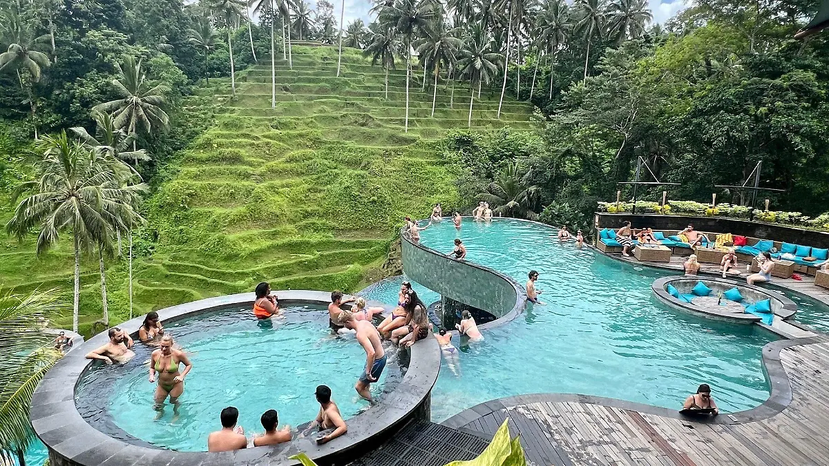 12.02.2024, Indonesien, Ubud: Touristen baden in einem Pool mit Blick auf die berühmten Reisterrassen von Tegallalang. Bali hat eine viel diskutierte «Tourism ax» eingeführt. Das Geld der Urlauber soll vor allem bei der Lösung des massiven Müllproblems helfen. (Zu: «Love Bali»: Trauminsel kassiert Touristensteuer) (zu dpa: ««Love Bali»: Trauminsel kassiert Touristensteuer») Foto: Carola Frentzen/dpa +++ dpa-Bildfunk +++