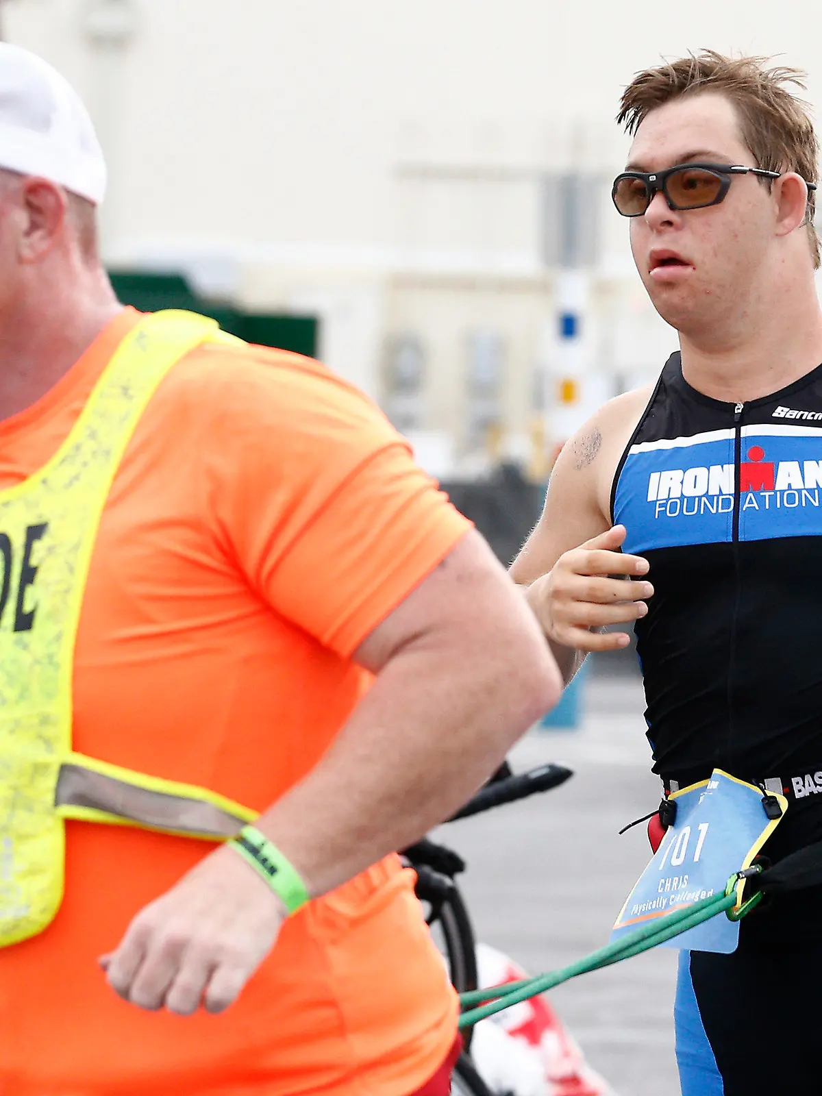 HANDOUT - 07.11.2020, USA, Panama City Beach: Chris Nikic (r) läuft neben seinem Trainer und Guide Dan Grieb, mit dem er mit einem Gurt verbunden ist, beim Ironman 2020. Nach Angaben der Veranstalter hat der 21 Jahre alte Amerikaner als erster Sportler mit Down-Syndrom einen Ironman absolviert. Für die 3,86 Kilometer Schwimmen, 180,2 Kilometer Radfahren und 42,2 Kilometer Laufen benötigte Chris Nikic beim Ironman Florida inoffiziell 16:46:09 Stunden. Foto: Michael Reaves/Getty Images North America/Getty Images for IRONMAN - ACHTUNG: Nur zur redaktionellen Verwendung im Zusammenhang mit der aktuellen Berichterstattung über den Ironman und nur mit vollständiger Nennung des vorstehenden Credits +++ dpa-Bildfunk +++