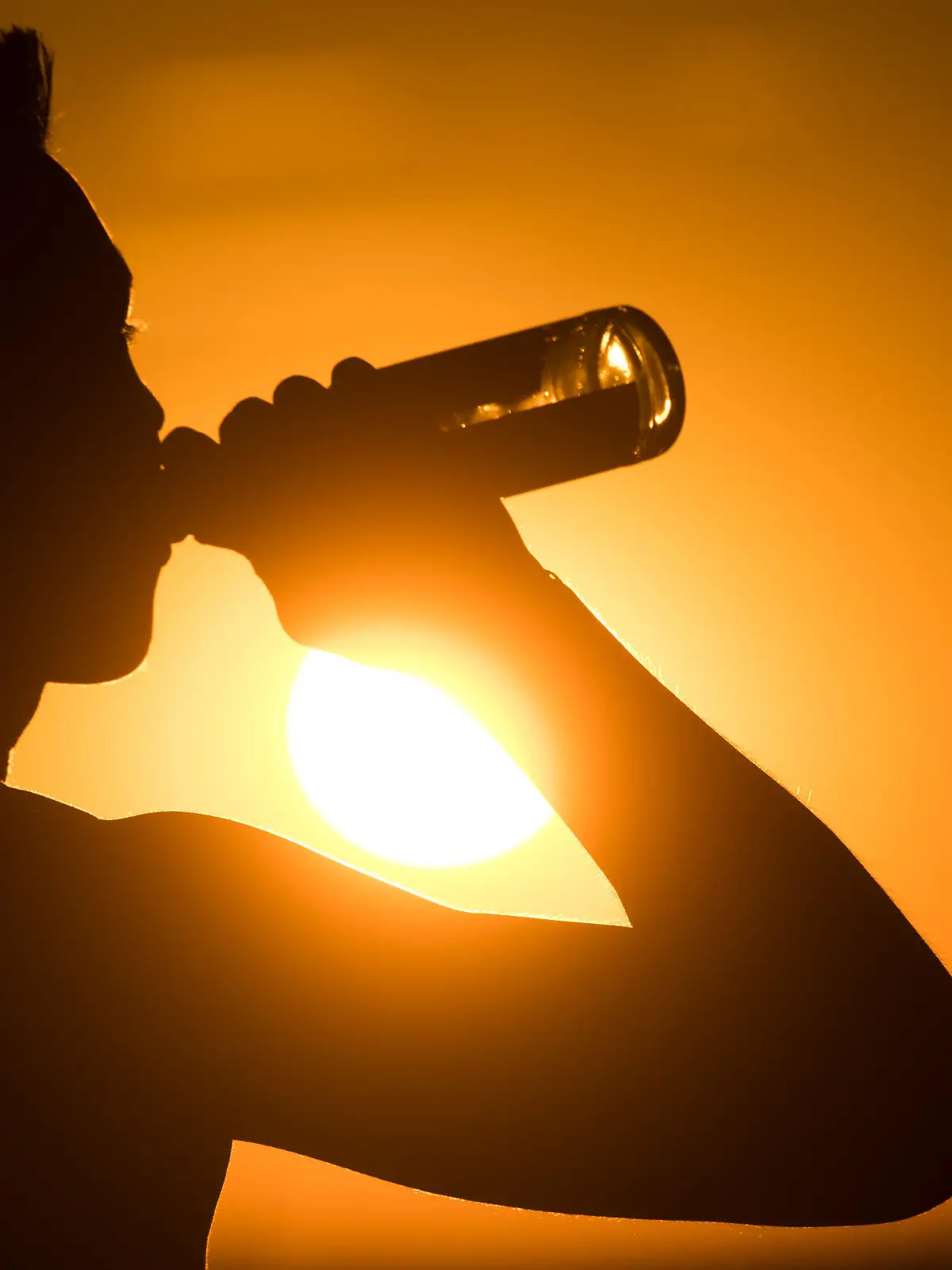 ARCHIV - 02.07.2018, Niedersachsen, Hannover: Ein junger Mann sitzt auf dem Kronsberg, und trinkt Bier, während am Horizont die Sonne untergeht. (zu dpa "Pool-Pinkler, Alkohol und Co.: Sieben Sommermythen im Faktencheck") Foto: Julian Stratenschulte/dpa +++ dpa-Bildfunk +++