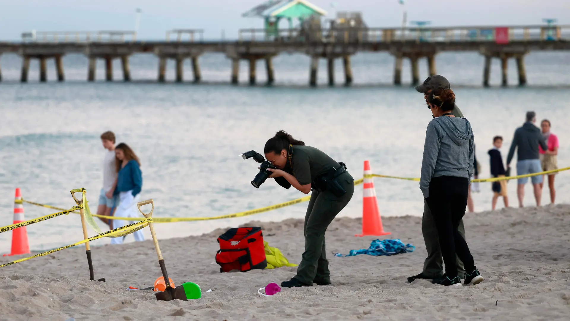 20.02.2024, USA, Lauderdale-by-the-Sea: Eine Polizistin macht am Strand von Lauderdale-by-the-Sea Fotos vom Tatort. Zwei Geschwisterkinder sind beim Buddeln am Strand von Lauderdale-by-the-Sea im Sand begraben worden. Eines der Kinder überlebte den Unfall nicht und wurde später im Krankenhaus für tot erklärt. Foto: Mike Stocker/South Florida Sun-Sentinel/AP/dpa +++ dpa-Bildfunk +++