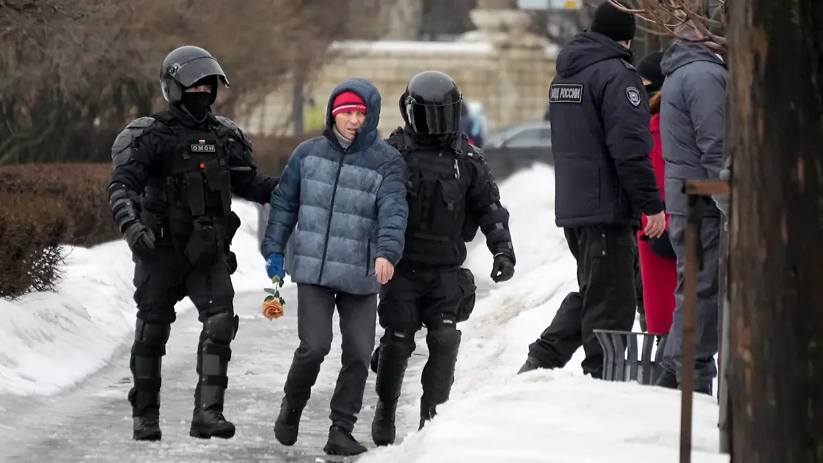Police detain a man as he wanted to lay flowers paying their last respect to Alexei Navalny at the monument, a large boulder from the Solovetsky islands, where the first camp of the Gulag political prison system was established, in St. Petersburg, Russia on Saturday, Feb. 17, 2024. Russian authorities say that Alexei Navalny, the fiercest foe of Russian President Vladimir Putin who crusaded against official corruption and staged massive anti-Kremlin protests, died in prison. He was 47. (AP Photo/Dmitri Lovetsky)