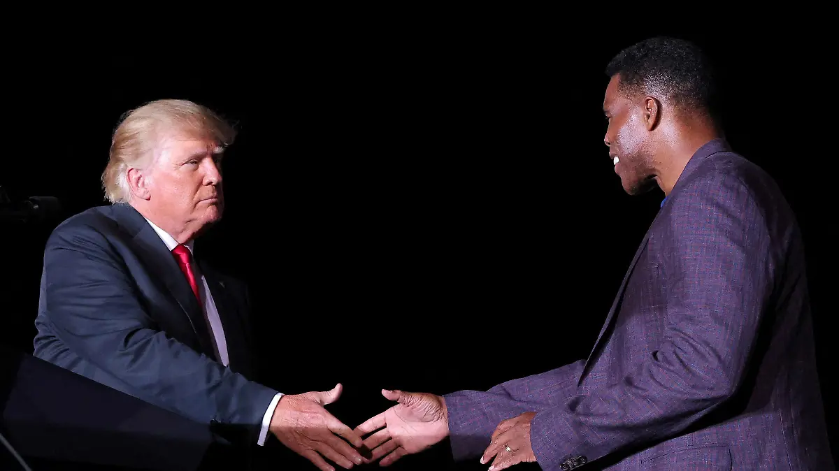 FILE PHOTO: Former college football star and current senatorial candidate Herschel Walker shakes hands with former U.S. President Donald Trump during a rally in Perry, Georgia, U.S. September 25, 2021. REUTERS/Dustin Chambers/File Photo