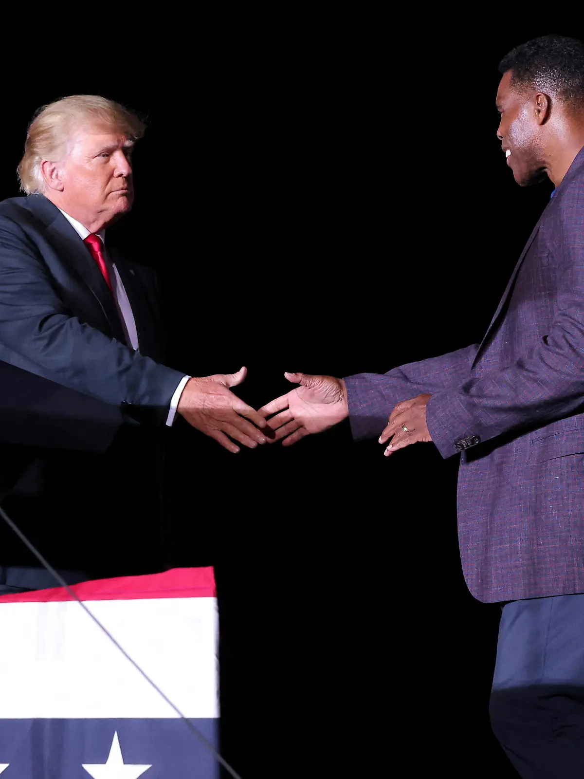 FILE PHOTO: Former college football star and current senatorial candidate Herschel Walker shakes hands with former U.S. President Donald Trump during a rally in Perry, Georgia, U.S. September 25, 2021. REUTERS/Dustin Chambers/File Photo