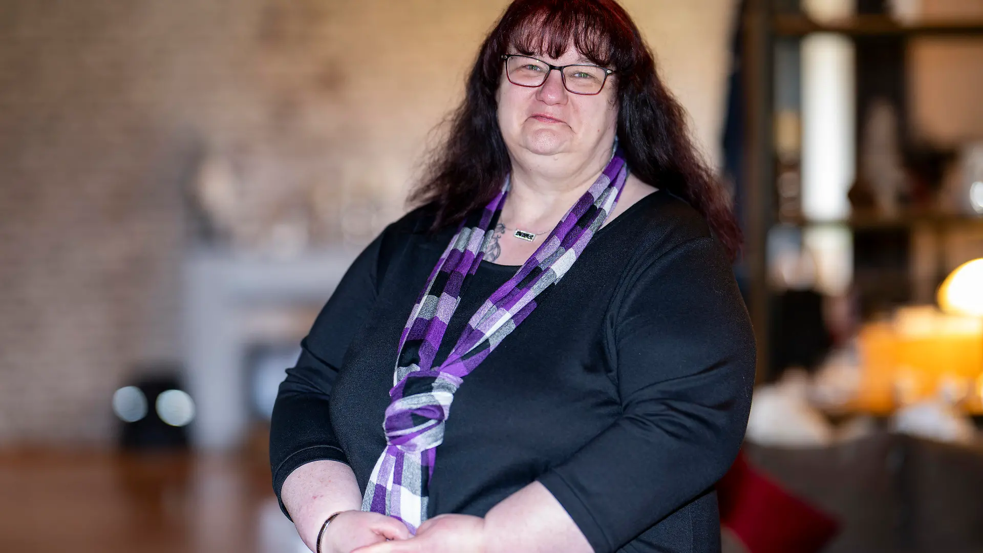 PRODUKTION - 14.02.2024, Niedersachsen, Bissendorf: Tanja Degner steht in ihrem Wohnzimmer. Die Frau leidet an Lipödem. Die gravierende chronische Erkrankung trifft fast ausschließlich Frauen. Eine fortschreitende Fettverteilungsstörung führt oft zu massiver Volumenzunahme vor allem an Armen und Beinen, geht meist einher mit starken Schmerzen, Hämatom-Neigung und psychischer Belastung.  (zu dpa: «Verbreitet und doch oft unerkannt: Fettgewebeerkrankung Lipödem verursacht schweres Leid») Foto: David Inderlied/dpa - ACHTUNG: Nur zur redaktionellen Verwendung im Zusammenhang mit der aktuellen Berichterstattung und nur mit vollständiger Nennung des vorstehenden Credits +++ dpa-Bildfunk +++