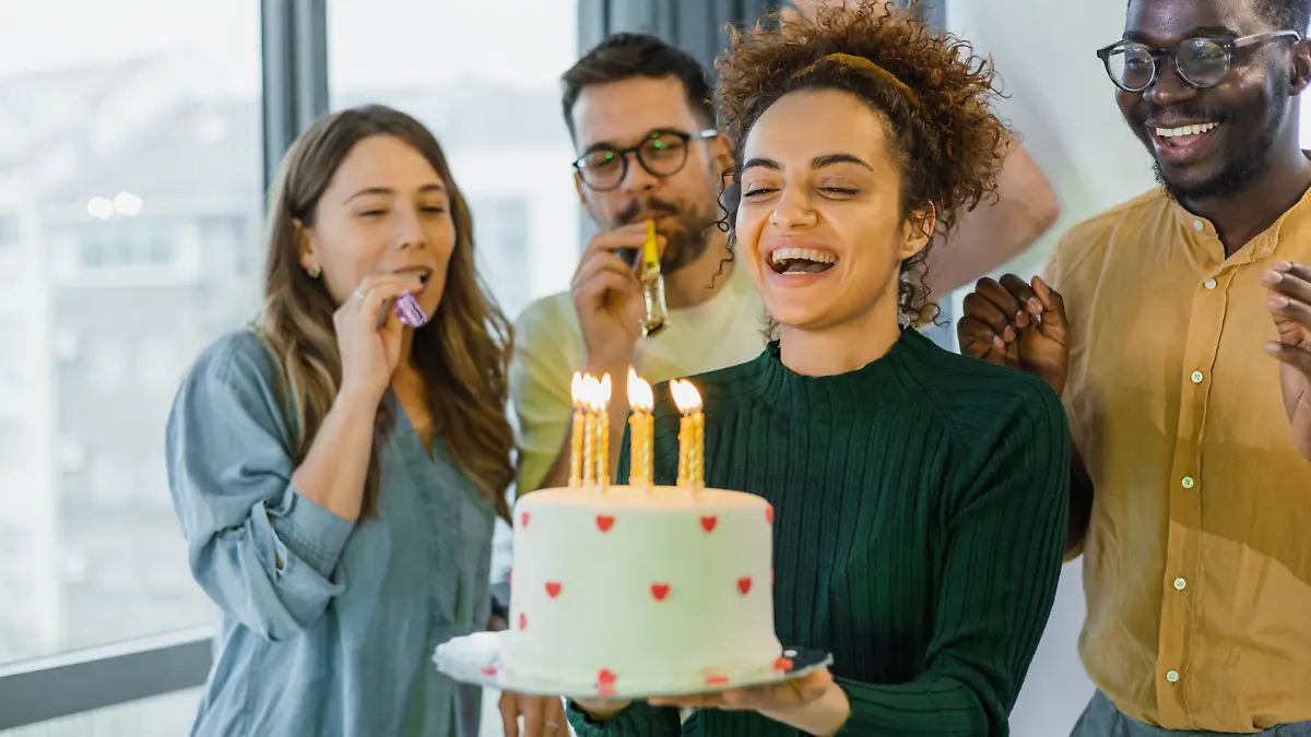 Four friends celebrating a birthday at home