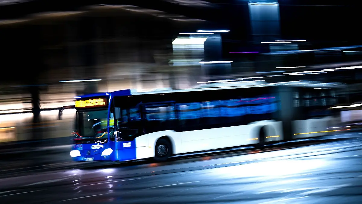 Ein Bus fährt an einem Bahnhof vorbei.