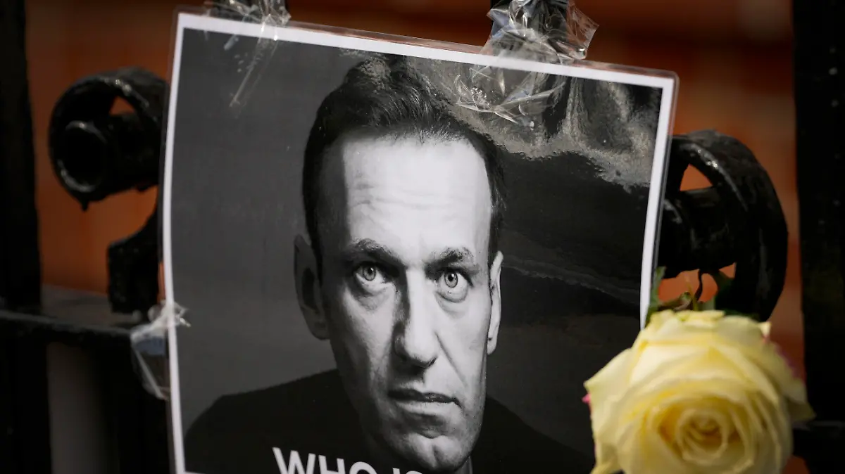 FILE - A flower and a picture are left as a tribute to Russian politician Alexei Navalny, near to the Russian Embassy in London, Feb. 18, 2024. The U.S. government is hitting Russia with the largest tranche of financial penalties imposed on Moscow since its 2022 invasion of Ukraine. They target roughly 600 people and firms from Russia to China to the United Arab Emirates. The sanctions are timed to the second anniversary of the invasion, and in response to the death of Navalny. (AP Photo/Kirsty Wigglesworth, File)