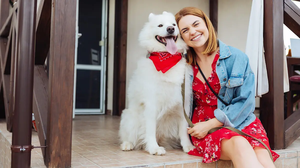 Woman with dog. Beaming fashionable woman feeling excited while coming to summer house with her dog