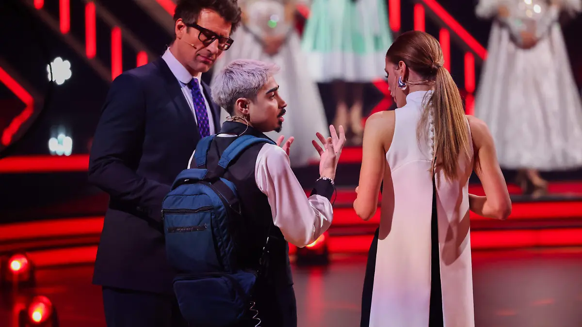 23.02.2024, Nordrhein-Westfalen, Kln: Tony Bauer (M), Comedian, erklärt Victoria Swarovski, und Daniel Hartwich, Moderatoren, seine Ernährung über einen Rucksack in der Kennenlernshow der RTL-Tanzshow «Let's Dance» zum Auftakt der neuen Staffel auf dem Parkett im Coloneum. Foto: Rolf Vennenbernd/dpa +++ dpa-Bildfunk +++