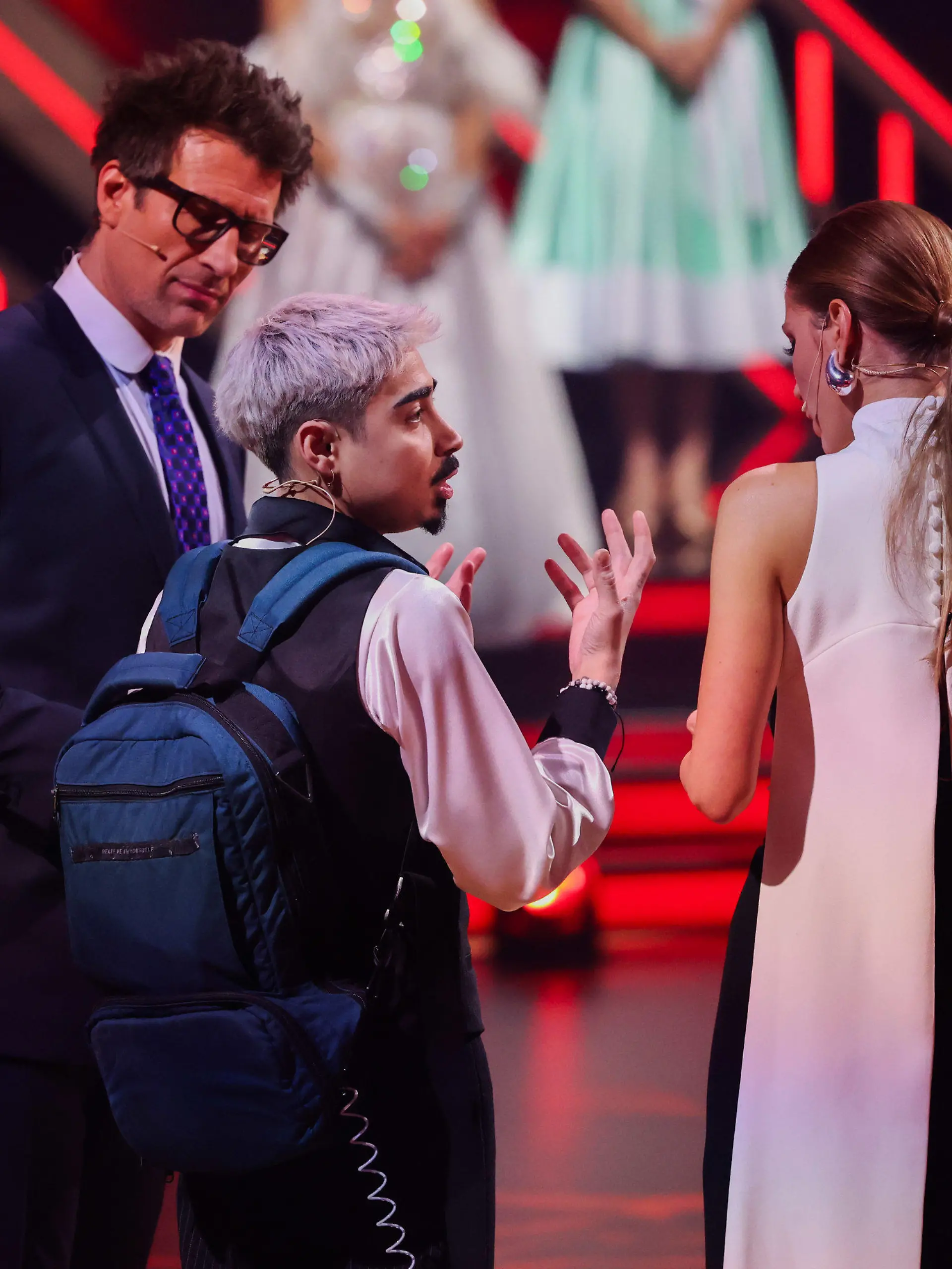 23.02.2024, Nordrhein-Westfalen, Kln: Tony Bauer (M), Comedian, erklärt Victoria Swarovski, und Daniel Hartwich, Moderatoren, seine Ernährung über einen Rucksack in der Kennenlernshow der RTL-Tanzshow «Let's Dance» zum Auftakt der neuen Staffel auf dem Parkett im Coloneum. Foto: Rolf Vennenbernd/dpa +++ dpa-Bildfunk +++