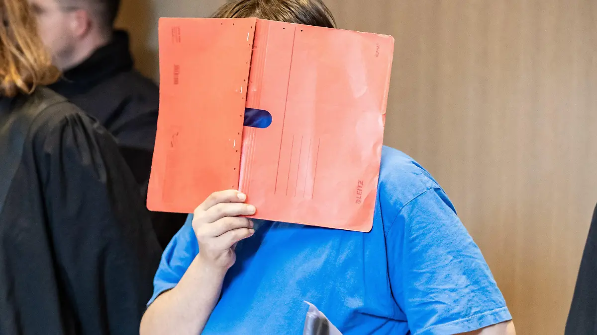 ARCHIV - 05.06.2020, Nordrhein-Westfalen, Bochum: Der Angeklagte steht zu Beginn seines Prozesses mit einem Aktenmappe vor dem Gesicht im Landgericht. Im Dezember 2019 hatte die Polizei im Schrank des Mannes aus Recklinghausen zufällig einen zweieinhalb Jahre lang vermissten Jungen entdeckt. Laut Staatsanwaltschaft ist der anfangs 13-Jährige über 400 Mal sexuell missbraucht worden. Am 02.09.2021 wollen die Richter am Bochumer Landgericht das Urteil sprechen. (zu dpa "Vermisster Junge im Schrank: Richter wollen Urteil sprechen") Foto: Marcel Kusch/dpa +++ dpa-Bildfunk +++