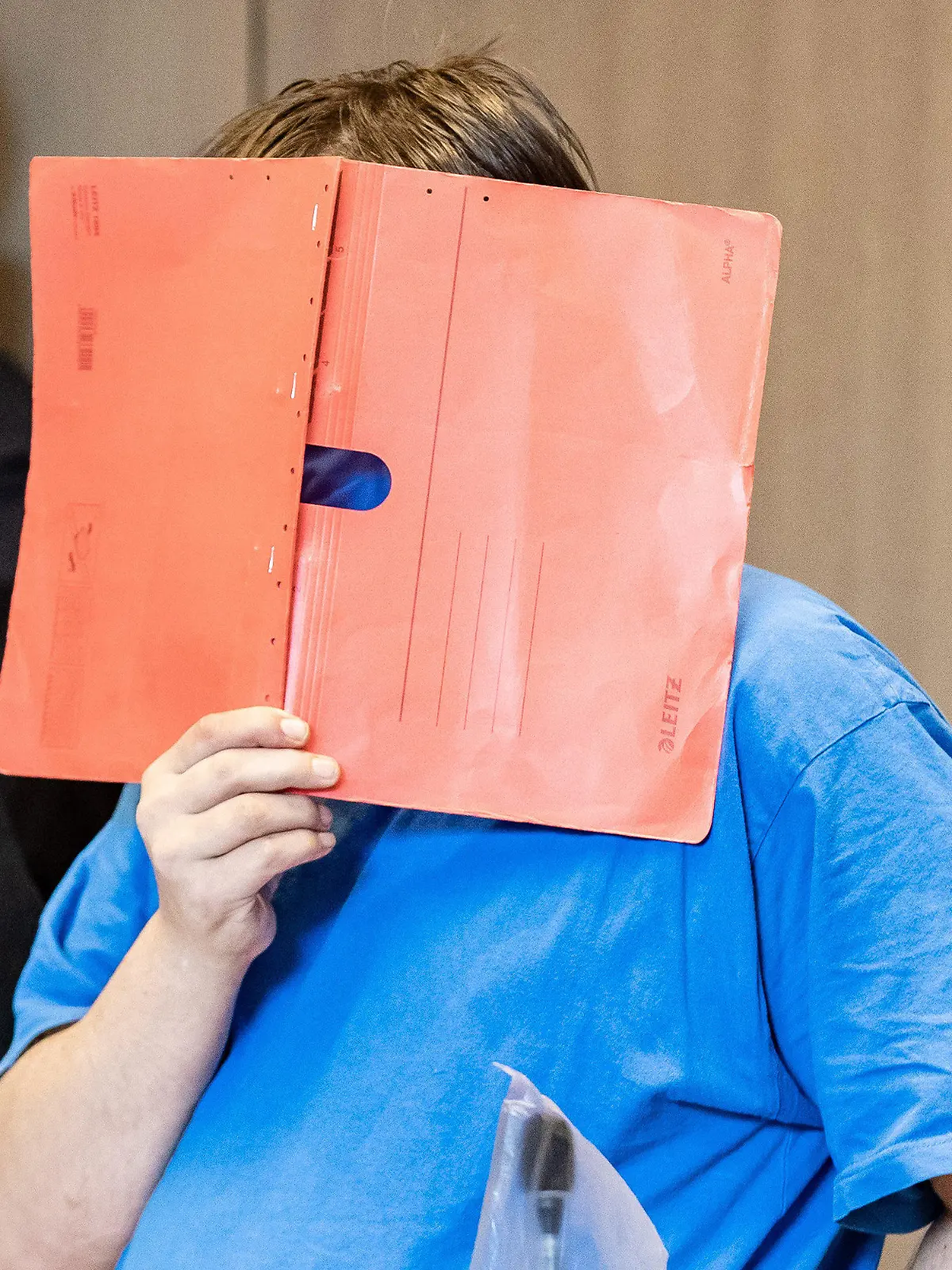 ARCHIV - 05.06.2020, Nordrhein-Westfalen, Bochum: Der Angeklagte steht zu Beginn seines Prozesses mit einem Aktenmappe vor dem Gesicht im Landgericht. Im Dezember 2019 hatte die Polizei im Schrank des Mannes aus Recklinghausen zufällig einen zweieinhalb Jahre lang vermissten Jungen entdeckt. Laut Staatsanwaltschaft ist der anfangs 13-Jährige über 400 Mal sexuell missbraucht worden. Am 02.09.2021 wollen die Richter am Bochumer Landgericht das Urteil sprechen. (zu dpa "Vermisster Junge im Schrank: Richter wollen Urteil sprechen") Foto: Marcel Kusch/dpa +++ dpa-Bildfunk +++