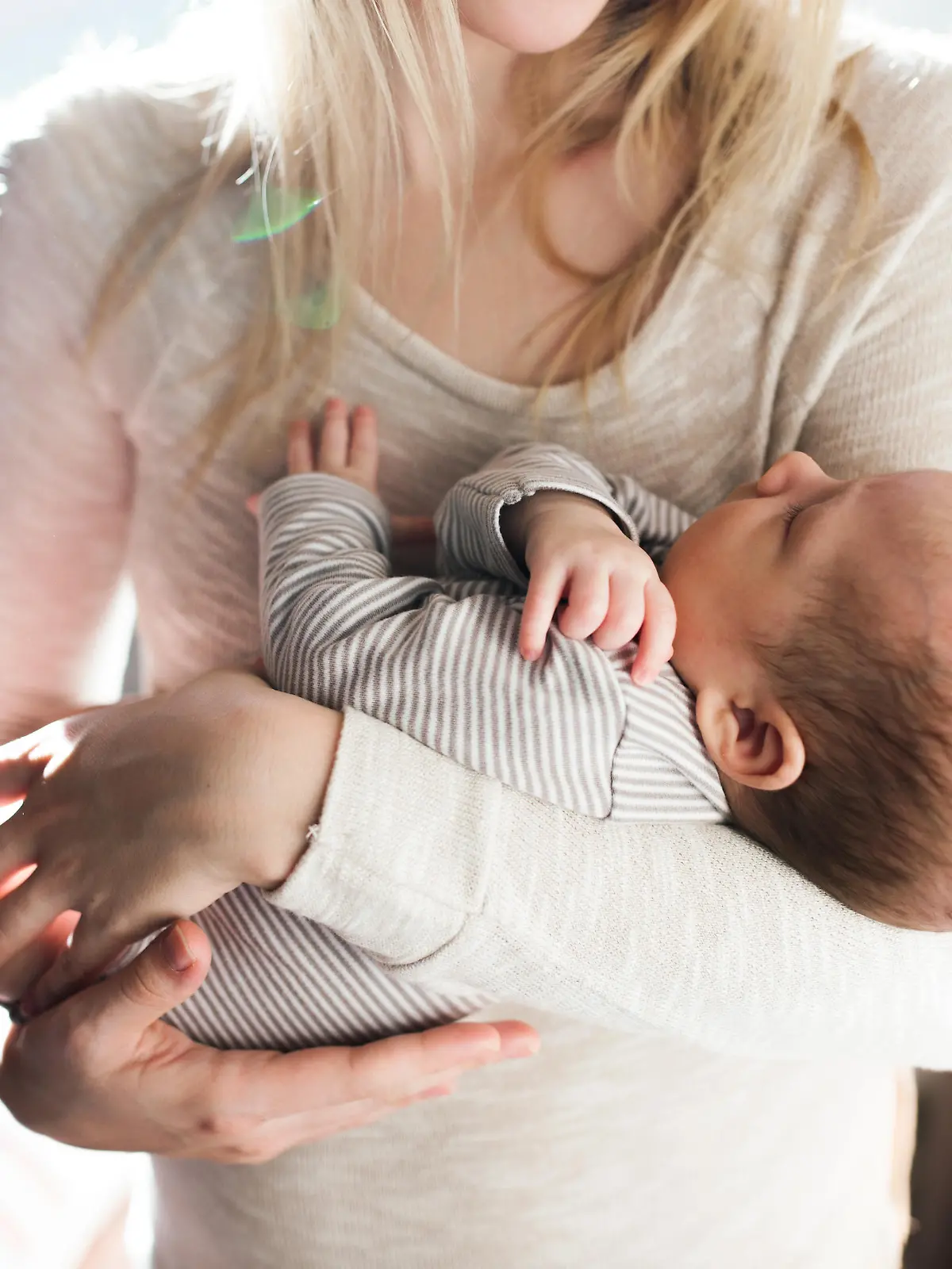 Unrecognizable young mother holding her baby son in her arms