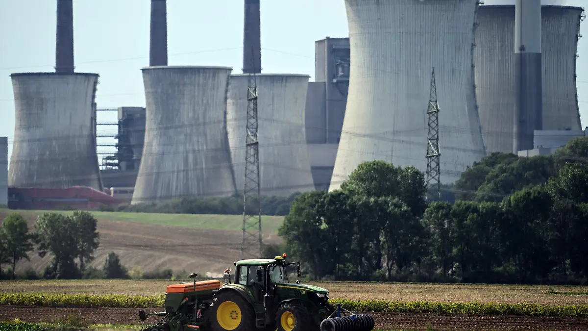 13.09.2022, Nordrhein-Westfalen, Allrath: Ein Landwirt nutzt das sonnige Wetter um vor der Kulisse des Braunkohlekraftwerks Neurath sein Feld zu bestellen. (Zu dpa "Gas sparen: Ältere Braunkohlekraftwerke dürfen wieder Strom erzeugen") Foto: Federico Gambarini/dpa +++ dpa-Bildfunk +++