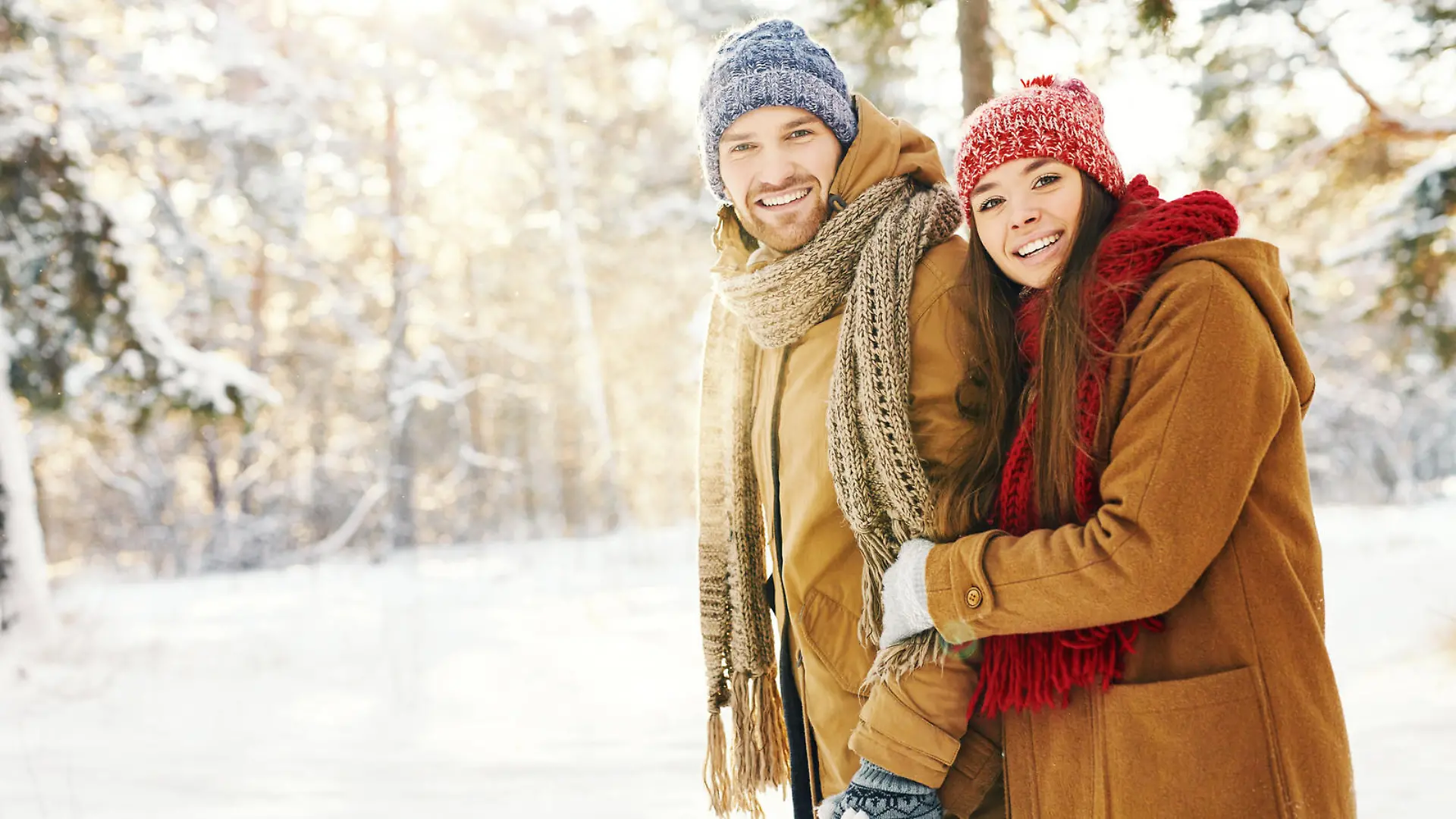Happy couple in winterwear taking walk in forest