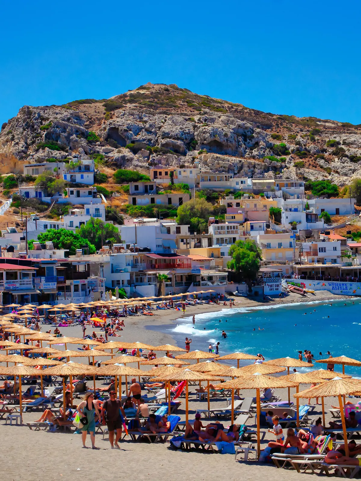 Urlauber entspannen am Strand von Matala auf der griechischen Insel Kreta