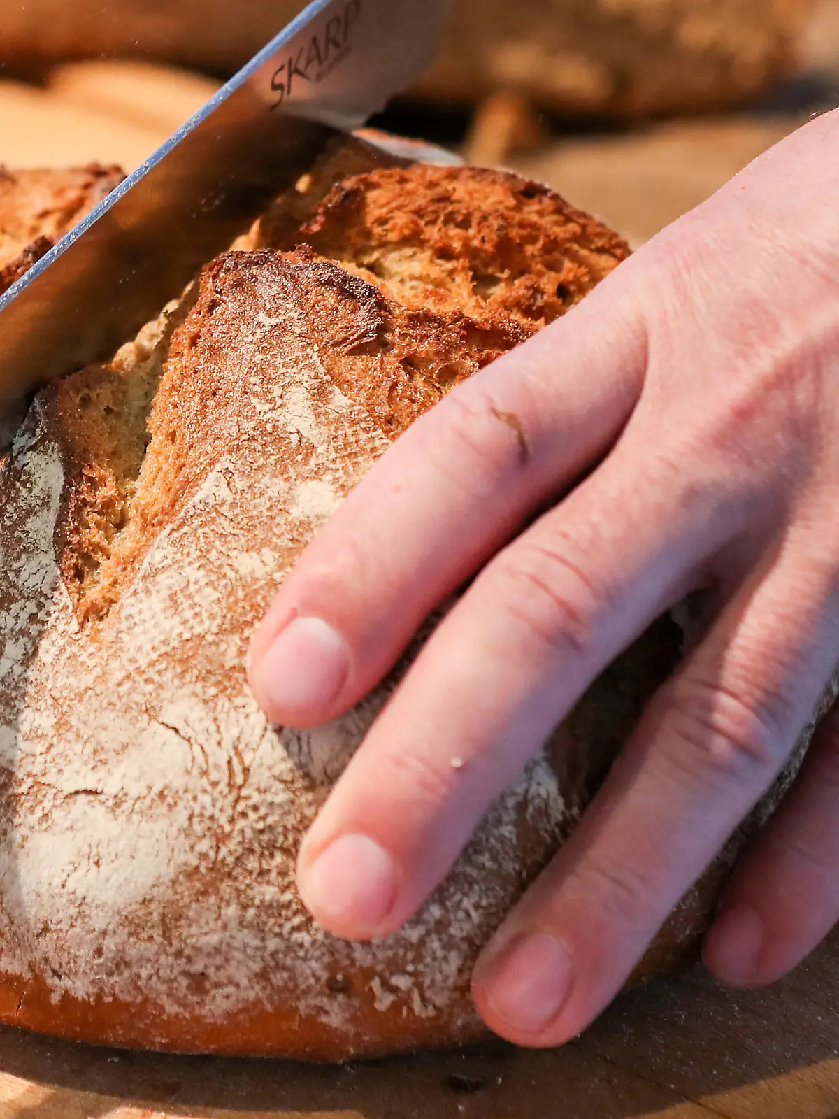 08.02.2019, Sachsen, Leipzig: Ein Mann schneidet in einer Leipziger Bäckerei mit einem Brotmesser ein Roggenmischbrot. Foto: Jan Woitas/dpa-Zentralbild/ZB