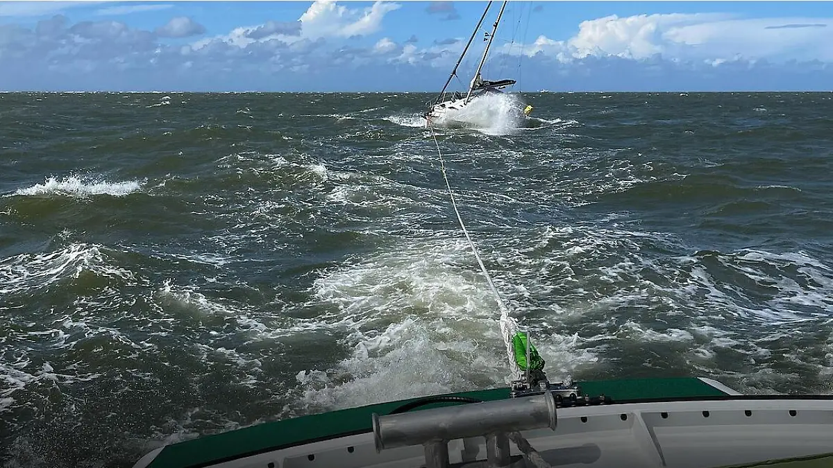 Mit einer Leine schleppen die Seenotretter das auf Grund gelaufene Schiff ab.