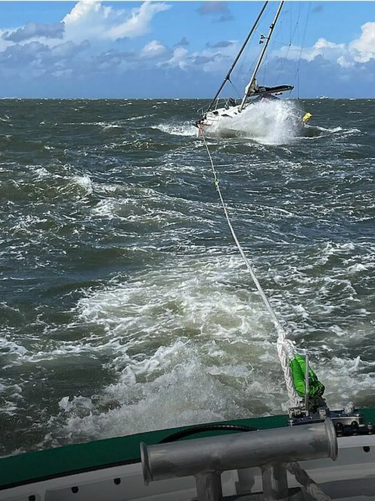 Mit einer Leine schleppen die Seenotretter das auf Grund gelaufene Schiff ab.
