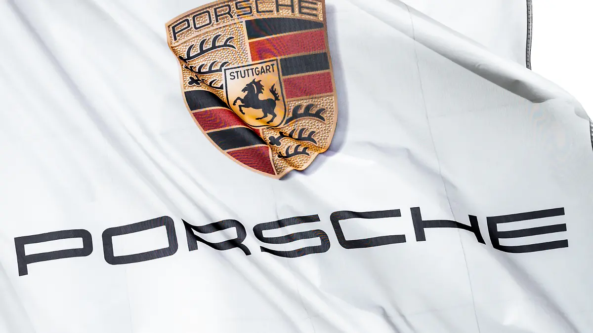 Das Logo von Porsche ist auf einer Flagge vor dem Porsche Zentrum Schwarzwald-Baar zu sehen, die im Wind weht. Villingen-Schwenningen Baden-Württemberg Deutschland *** The Porsche logo can be seen on a flag in front of the Porsche Centre Schwarzwald Baar blowing in the wind Villingen Schwenningen Baden Württemberg Germany