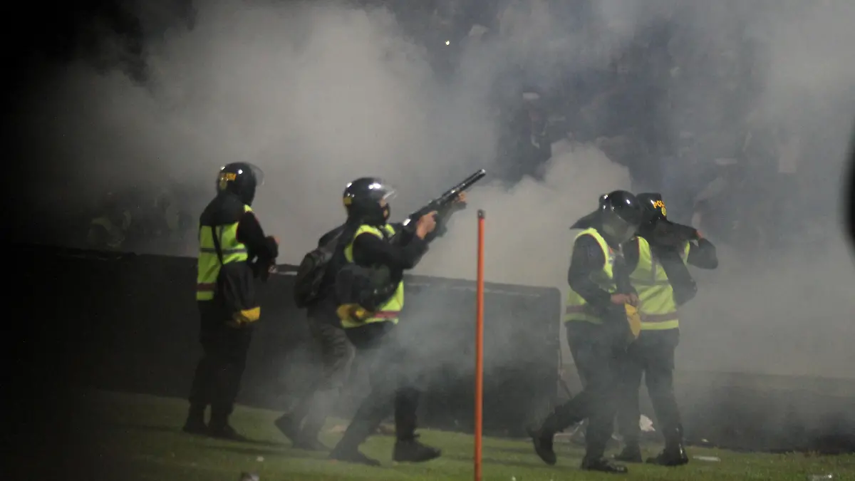 A riot police officer fires tear gas during a riot after the league BRI Liga 1 football match between Arema vs Persebaya at Kanjuruhan Stadium in Malang, East Java province, Indonesia, October 2, 2022, in this photo taken by Antara Foto. Antara Foto/Ari Bowo Sucipto/via REUTERS ATTENTION EDITORS - THIS IMAGE HAS BEEN SUPPLIED BY A THIRD PARTY. MANDATORY CREDIT. INDONESIA OUT. NO COMMERCIAL OR EDITORIAL SALES IN INDONESIA.